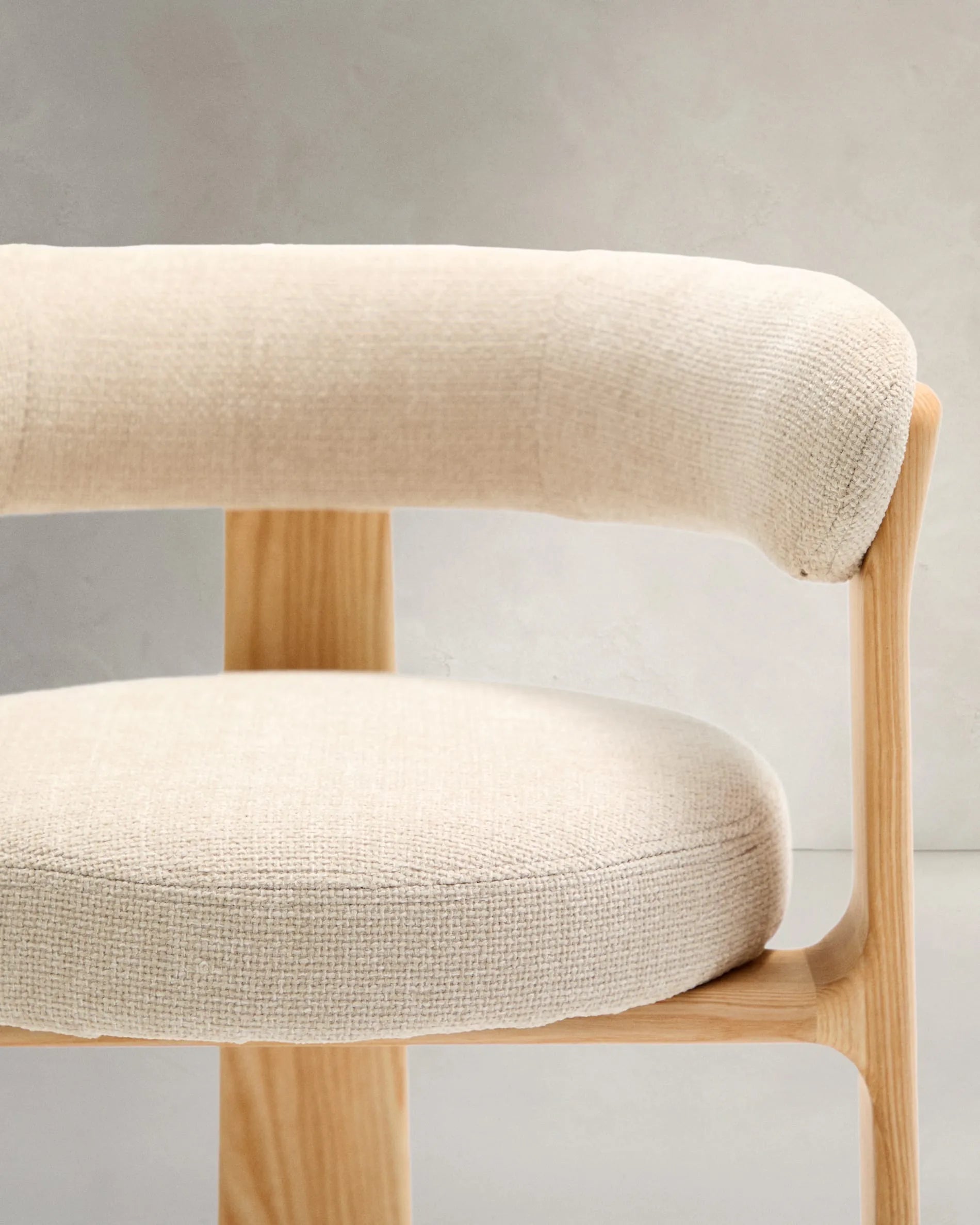 Eleganter 3-beiniger Stuhl mit beiger Chenille-Polsterung, aus massivem Eschenholz mit natürlichem Finish, FSC-zertifiziert, von Kave Home.