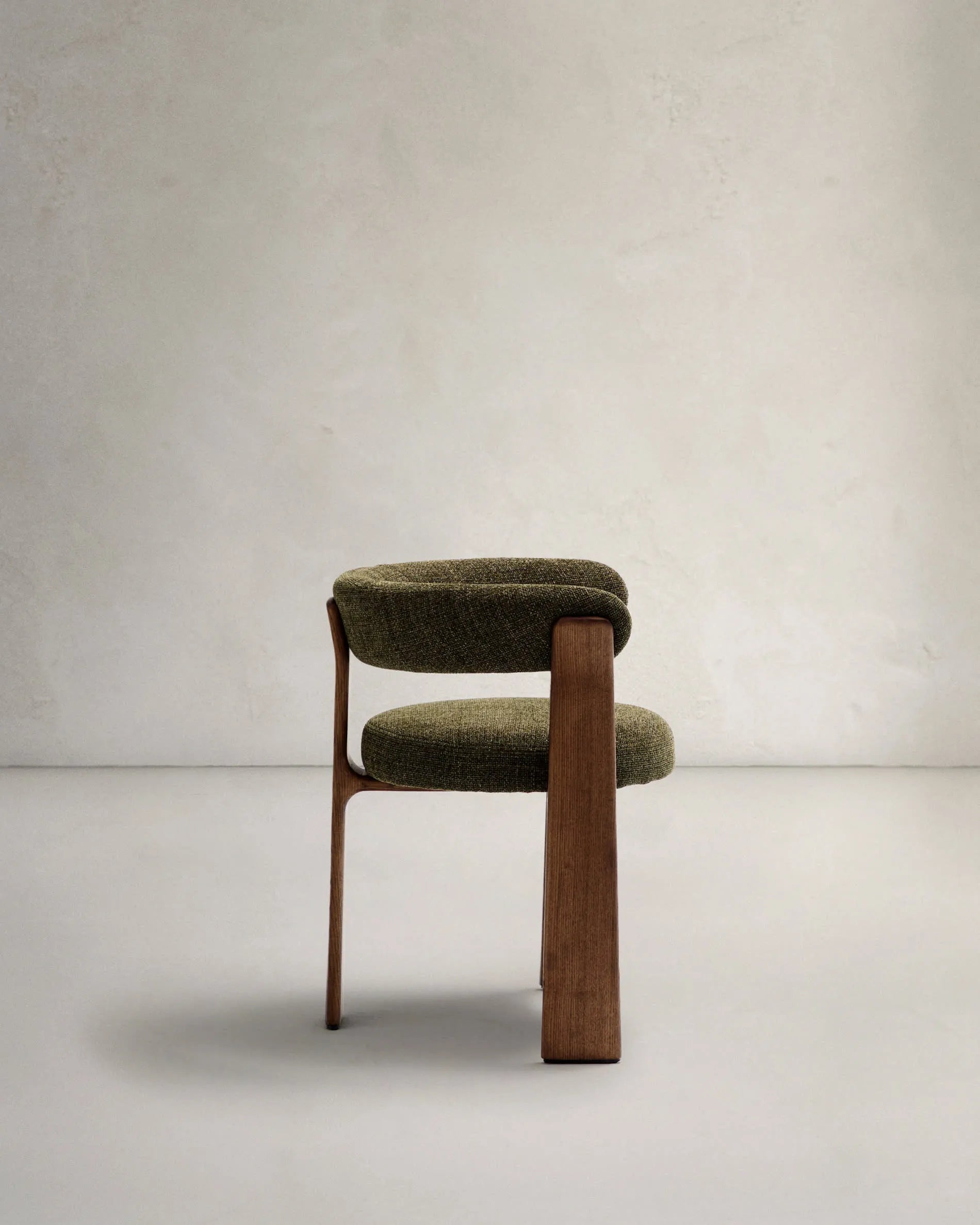 Moderner Stuhl mit grünem Chenille-Bezug, dreibeinigem Eschenholzgestell in Walnuss-Finish, FSC-zertifiziert, von Kave Home.
