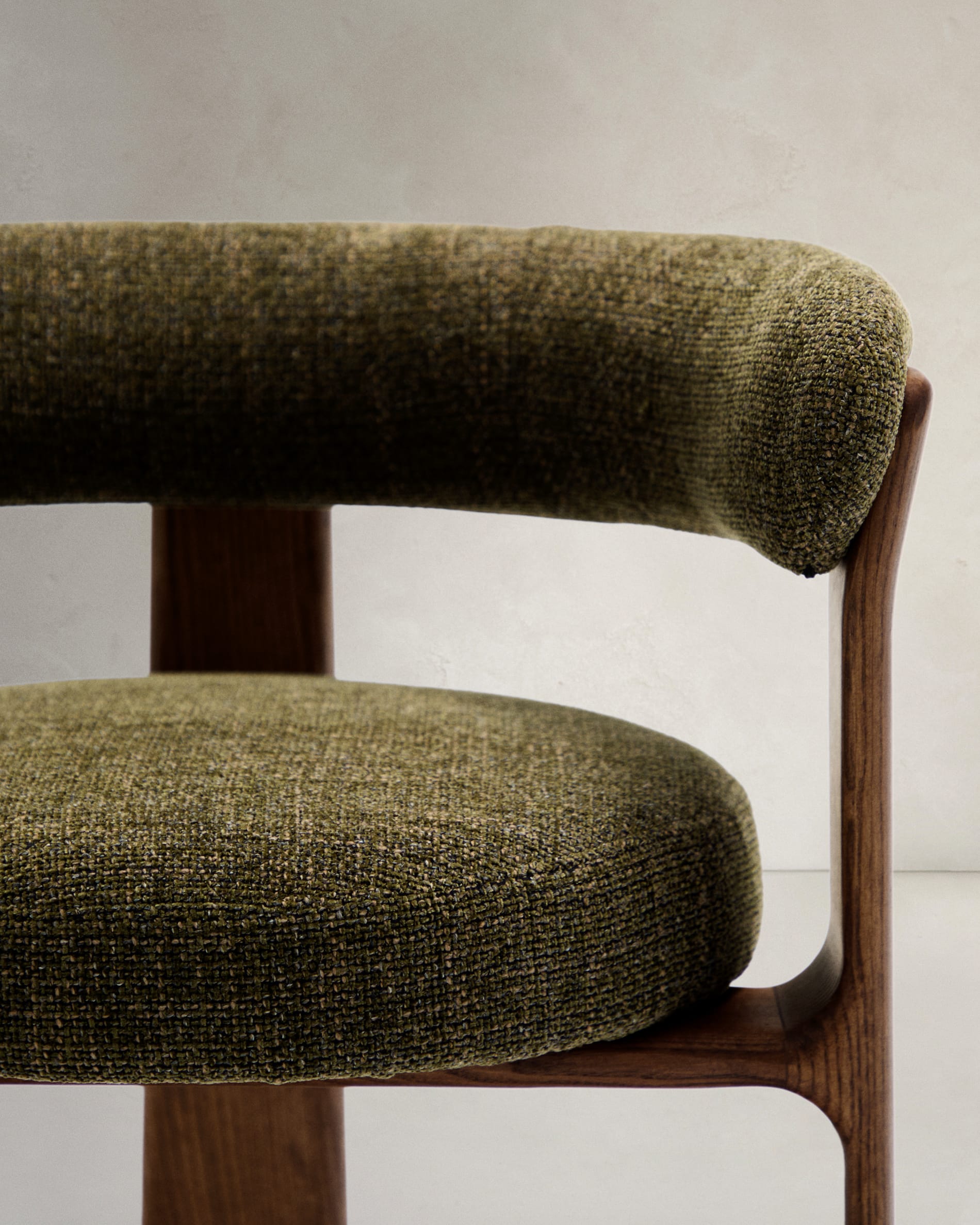 Eleganter Stuhl mit grünem Chenille-Stoff, dreibeinigem Eschenholzgestell in Walnussoptik, FSC-zertifiziert, von Kave Home.