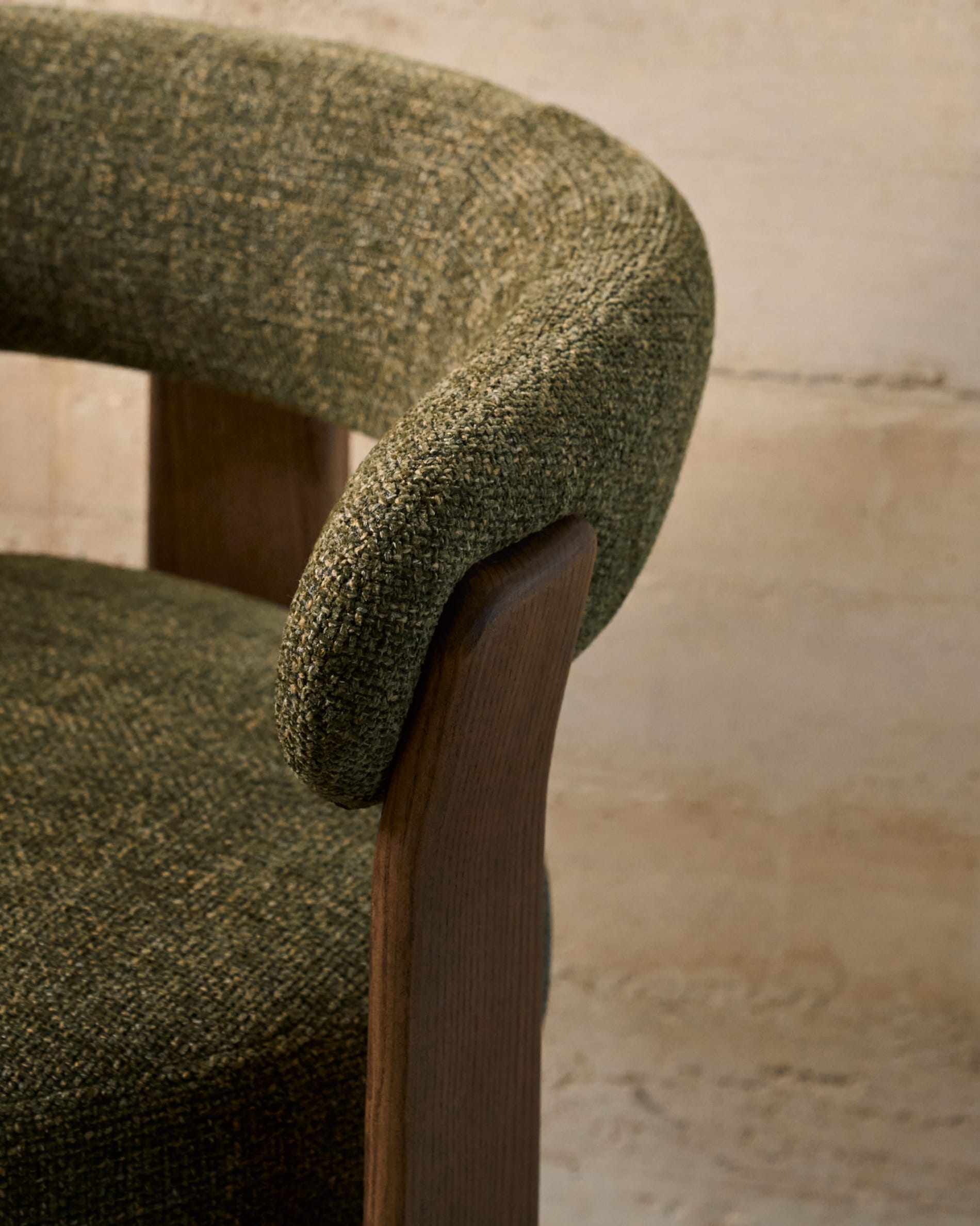 Eleganter Stuhl mit grünem Chenille-Stoff, dreibeinigem Eschenholzgestell in Walnussoptik, FSC-zertifiziert, von Kave Home.