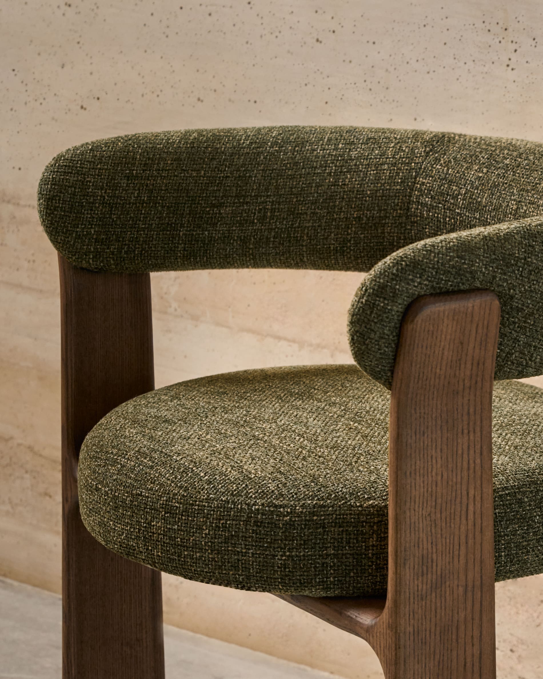 Eleganter Stuhl mit grünem Chenille-Stoff, dreibeinigem Eschenholzgestell in Walnussoptik, FSC-zertifiziert, von Kave Home.