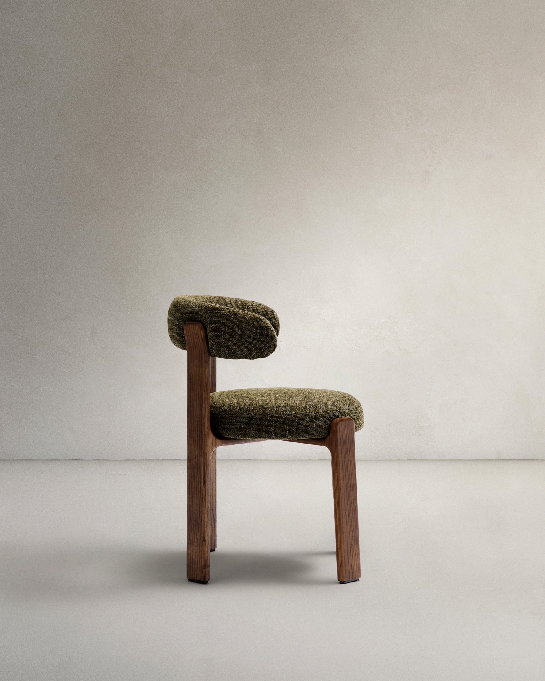 Eleganter Stuhl aus grüner Chenille und FSC-zertifiziertem Eschenholz mit Walnuss-Finish, ideal für stilvolles und umweltbewusstes Wohnen.