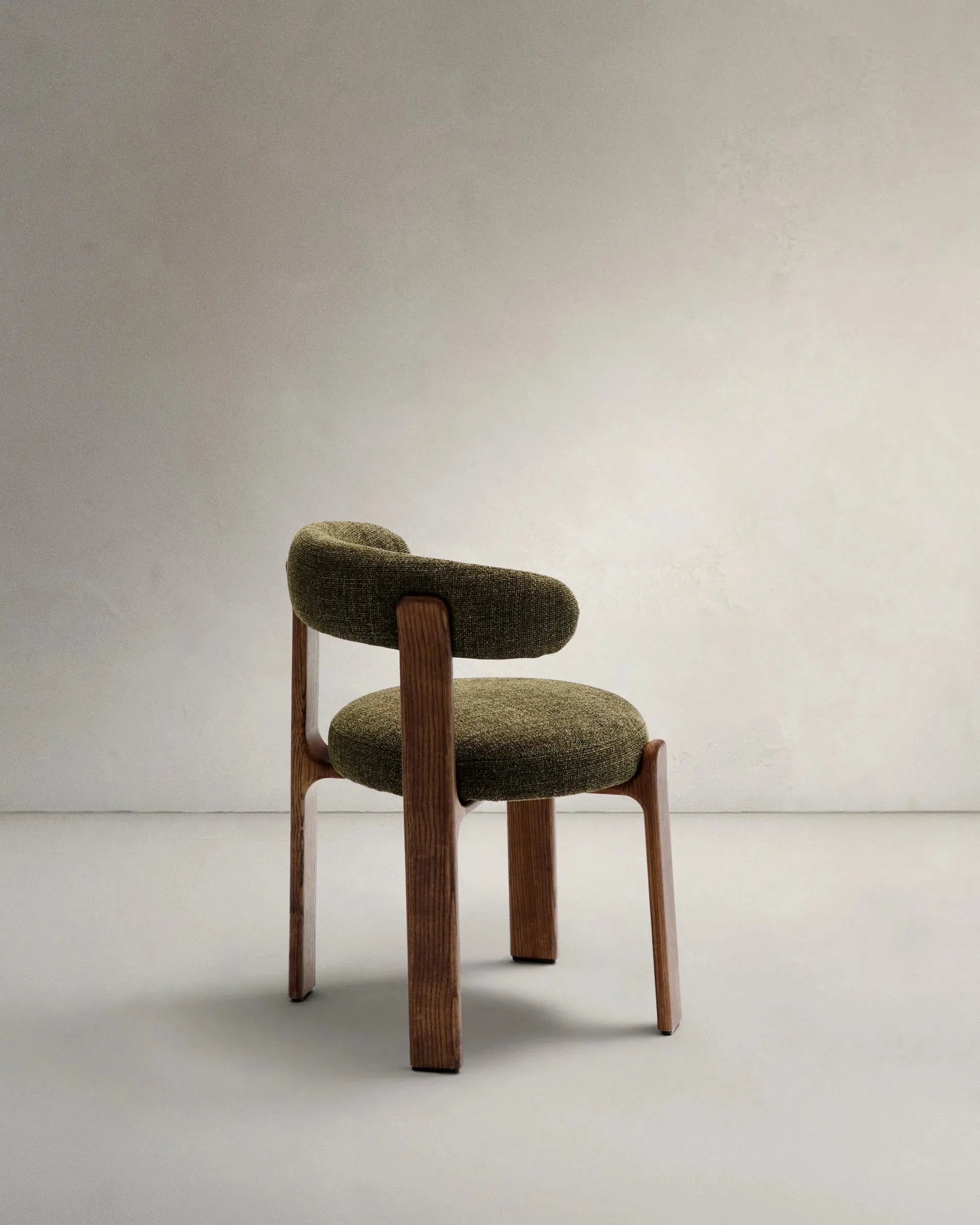 Moderner Stuhl aus grüner Chenille und FSC-zertifiziertem Eschenholz mit Walnuss-Finish, perfekt für nachhaltiges und elegantes Interieur.