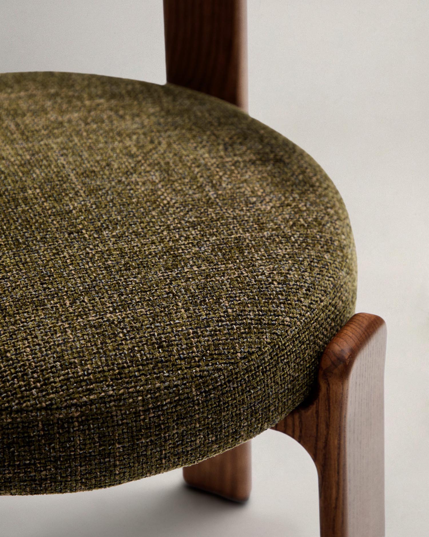 Moderner Stuhl aus grüner Chenille und FSC-zertifiziertem Eschenholz mit Walnuss-Finish, perfekt für nachhaltiges und elegantes Interieur.