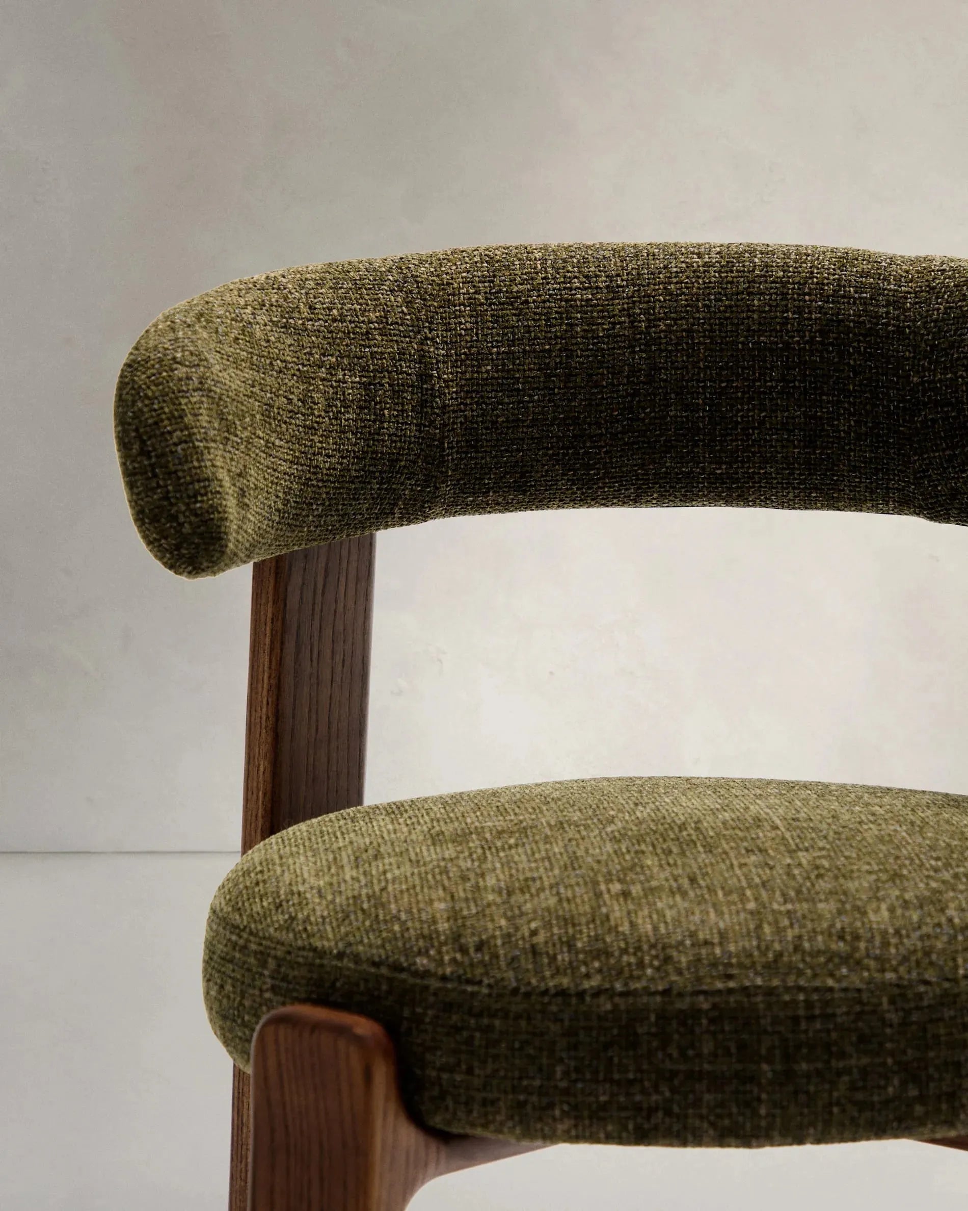 Moderner Stuhl aus grüner Chenille und FSC-zertifiziertem Eschenholz mit Walnuss-Finish, perfekt für nachhaltiges und elegantes Interieur.