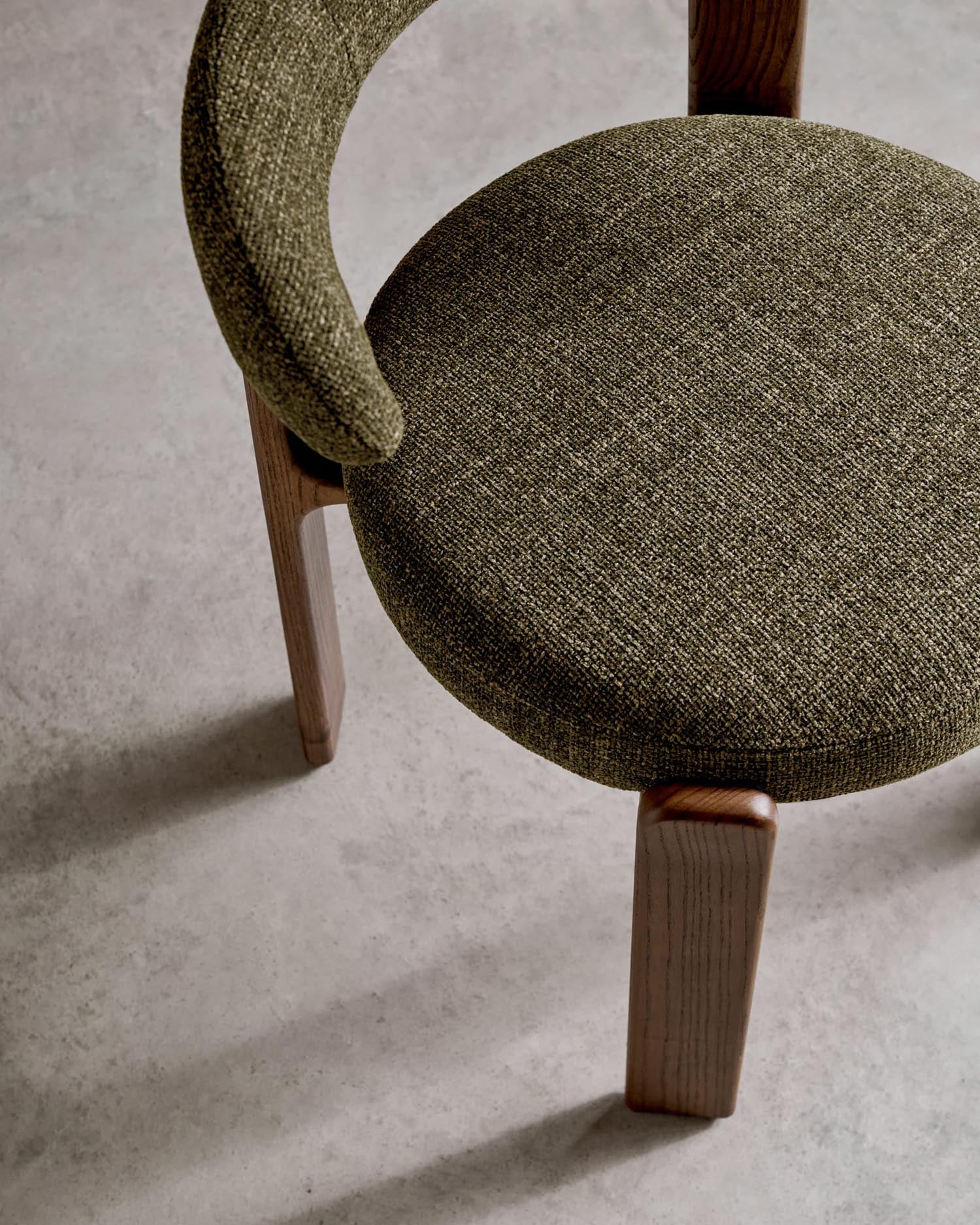 Moderner Stuhl aus grüner Chenille und FSC-zertifiziertem Eschenholz mit Walnuss-Finish, perfekt für nachhaltiges und elegantes Interieur.