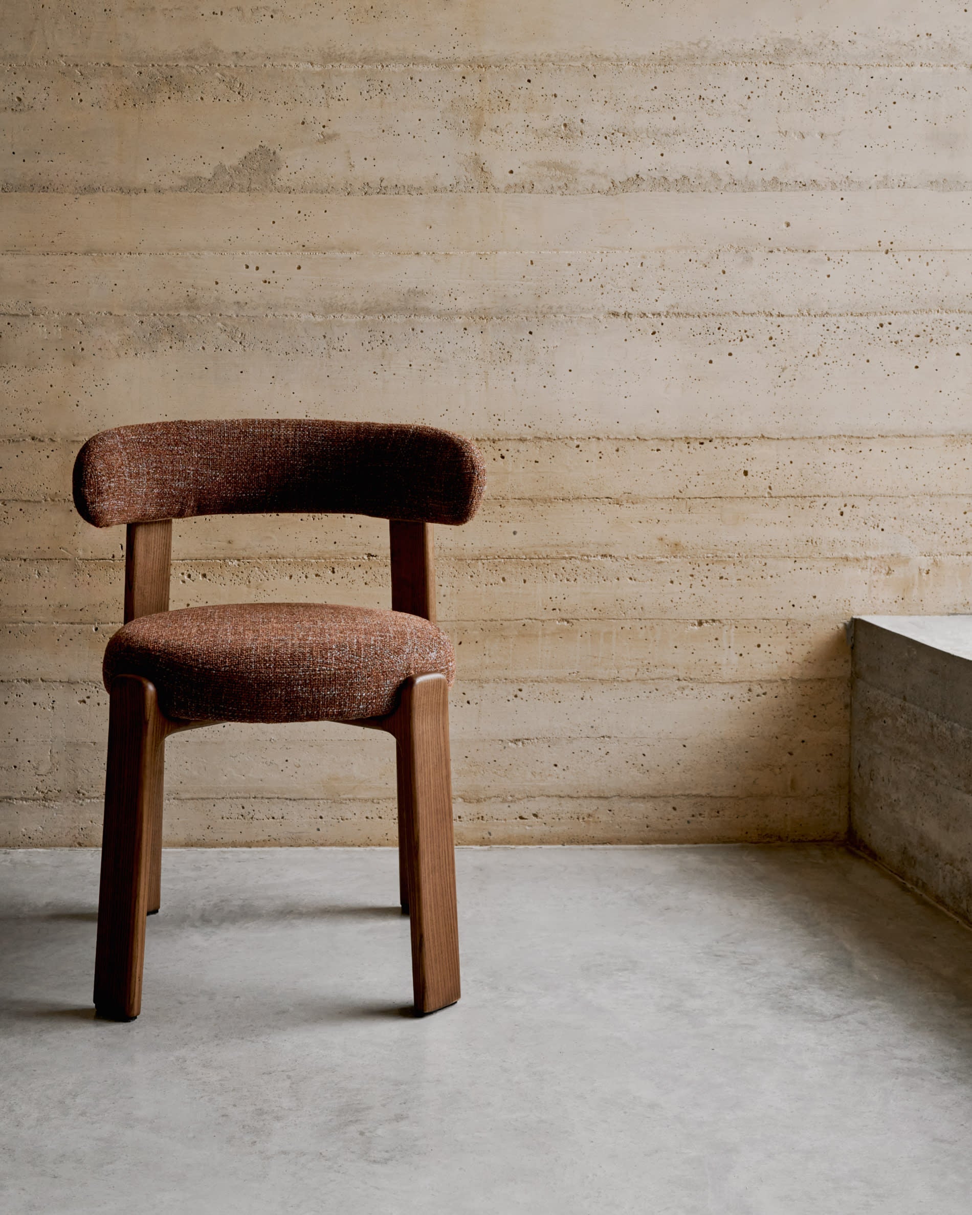 Eleganter Stuhl aus brauner Chenille und FSC-zertifiziertem Eschenholz mit Walnuss-Finish, perfekt für moderne Wohnräume.