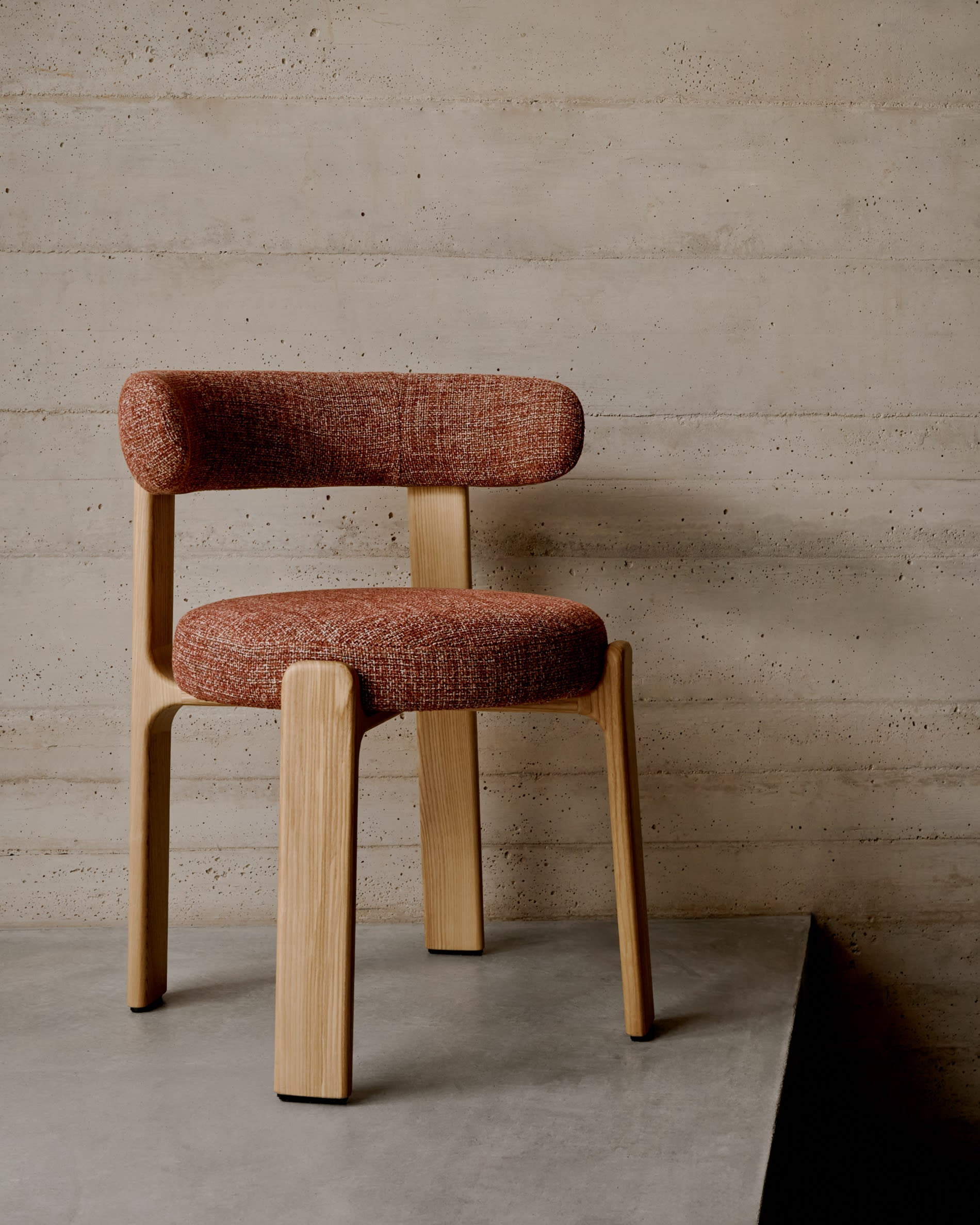 Eleganter Stuhl mit terrakottafarbener Chenille-Polsterung, massivem Eschenholzrahmen und natürlichem Finish, FSC-zertifiziert und nachhaltig.
