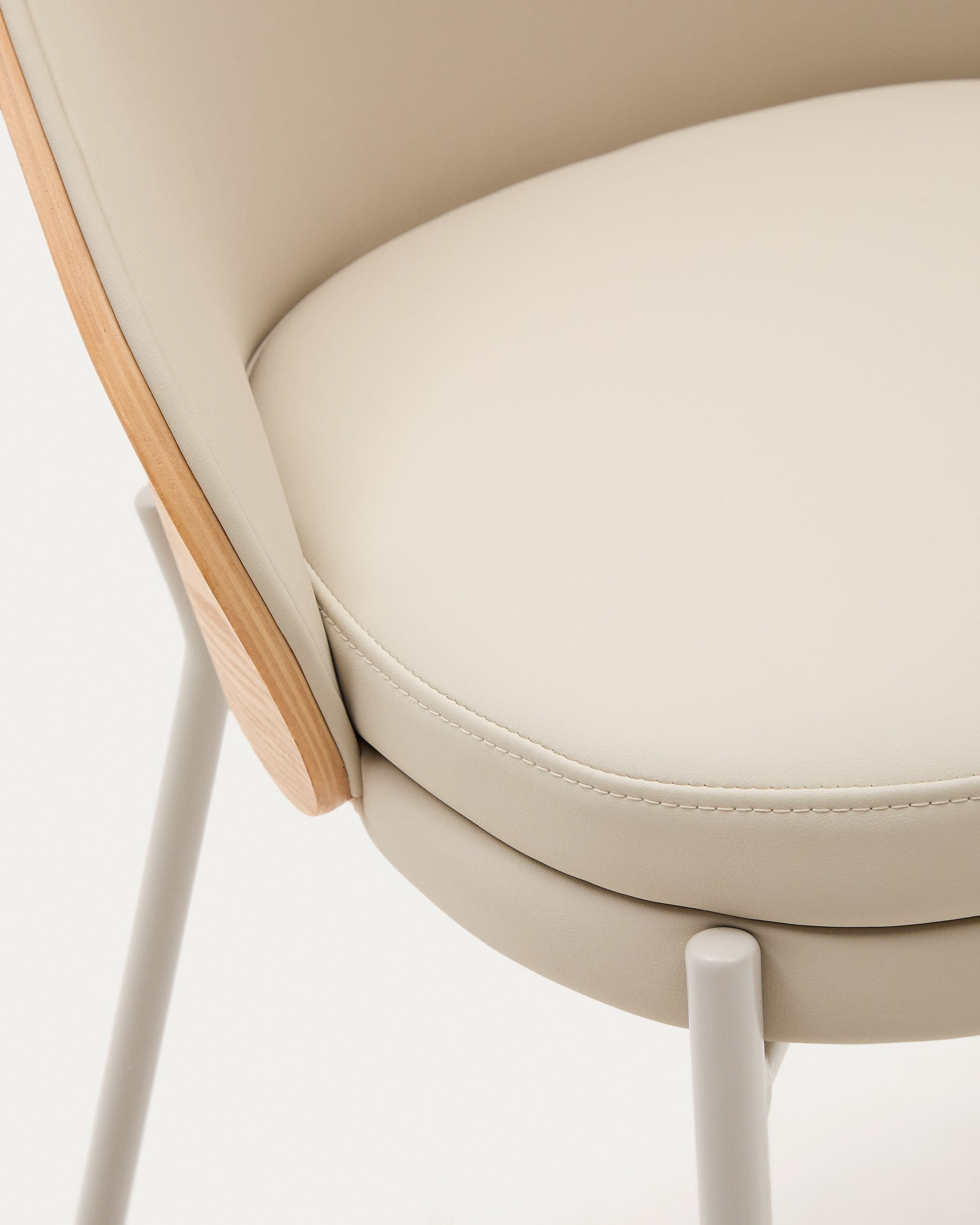 Moderner Eamy Stuhl in beigem Kunstleder und naturfarbenem Eschenfurnier, ergänzt durch stilvolle Metallakzente – ideal für jedes Esszimmer.