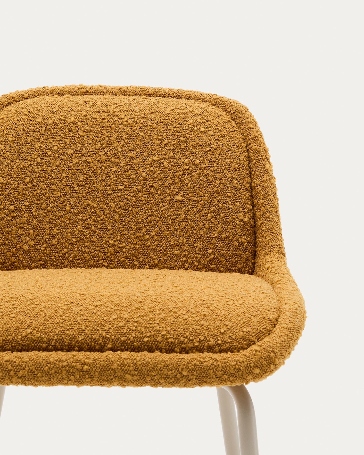 Stilvoller Aimin Hocker in Senfgelb aus Bouclé mit stabilen Stahlbeinen in Beige. 65 cm hoch, FSC-zertifiziert und ideal für jeden Raum.