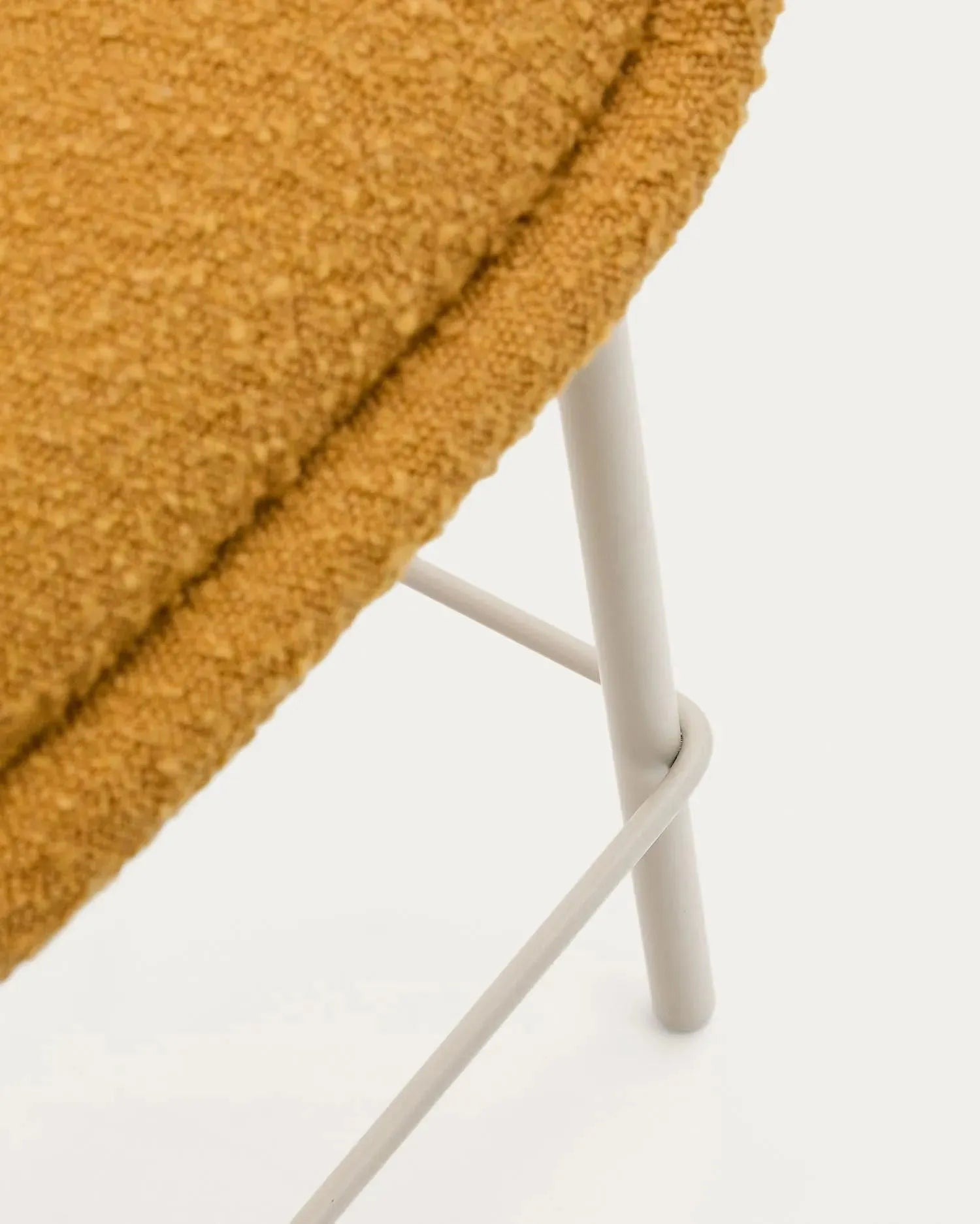 Eleganter Hocker Aimin mit senfgelbem Bouclé-Stoff, stabilen beige lackierten Stahlbeinen, 65 cm hoch, FSC-zertifiziert von Kave Home.