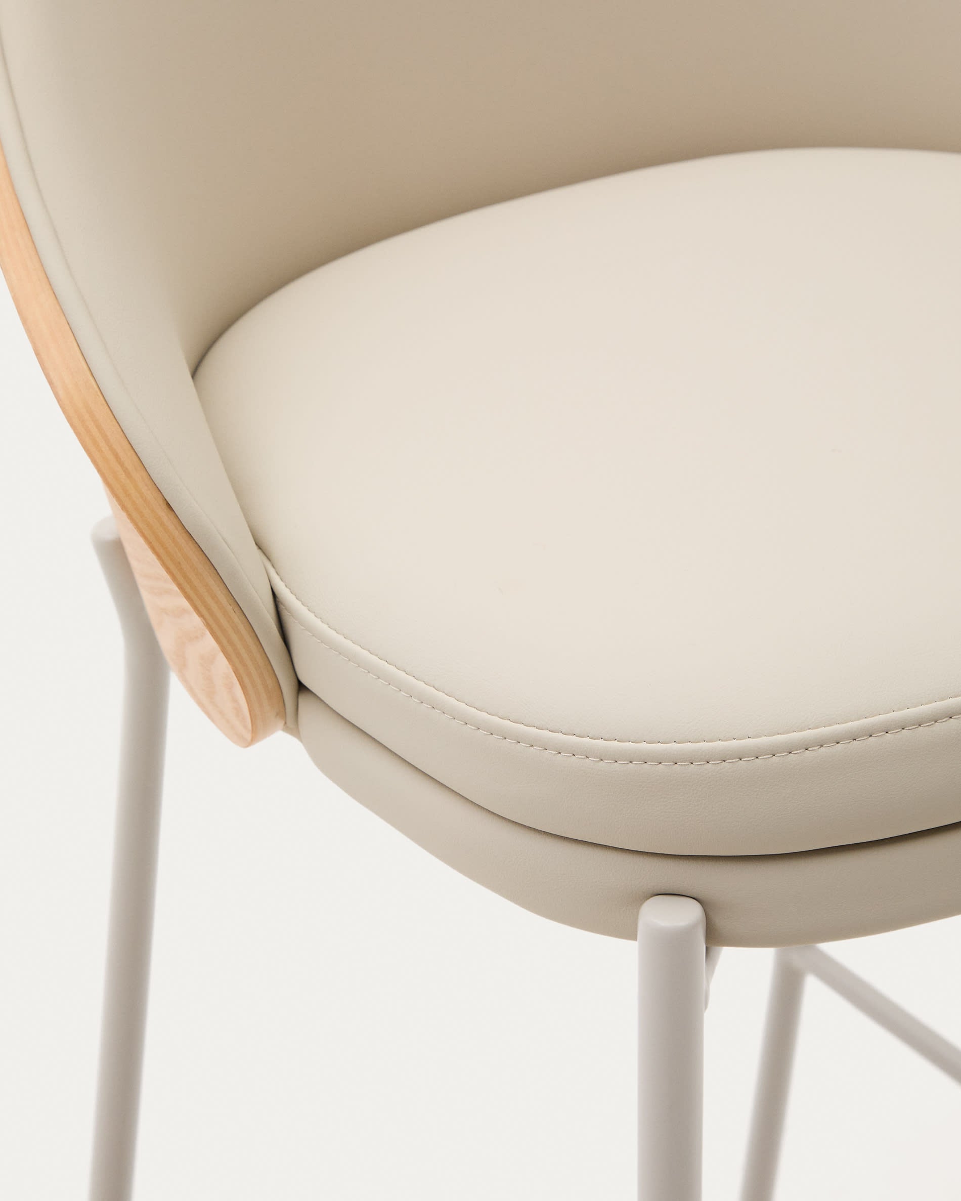 Eleganter Eamy Hocker mit beigem Kunstleder, natürlichem Eschenfurnier und Metallakzenten, perfekt für moderne Wohnräume.
