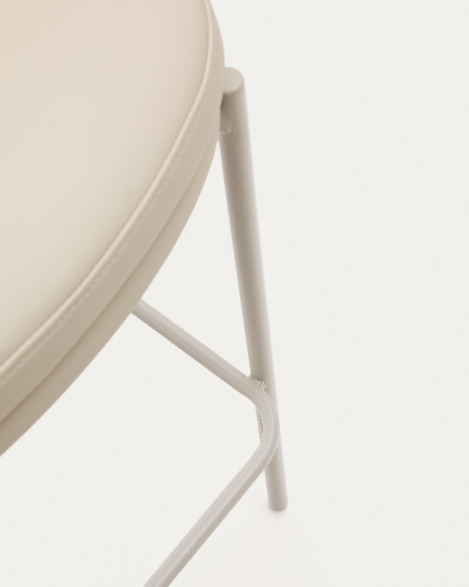 Eleganter Eamy Hocker mit beigem Kunstleder, natürlichem Eschenfurnier und Metallakzenten, perfekt für moderne Wohnräume.