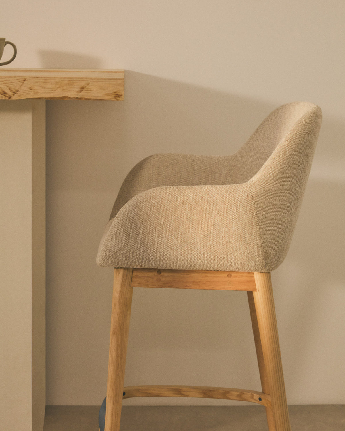 Beigefarbener Hocker Konna mit Beinen aus massivem Eschenholz, helles Finish 65 cm in Beige präsentiert im Onlineshop von KAQTU Design AG. Barstuhl ist von Kave Home