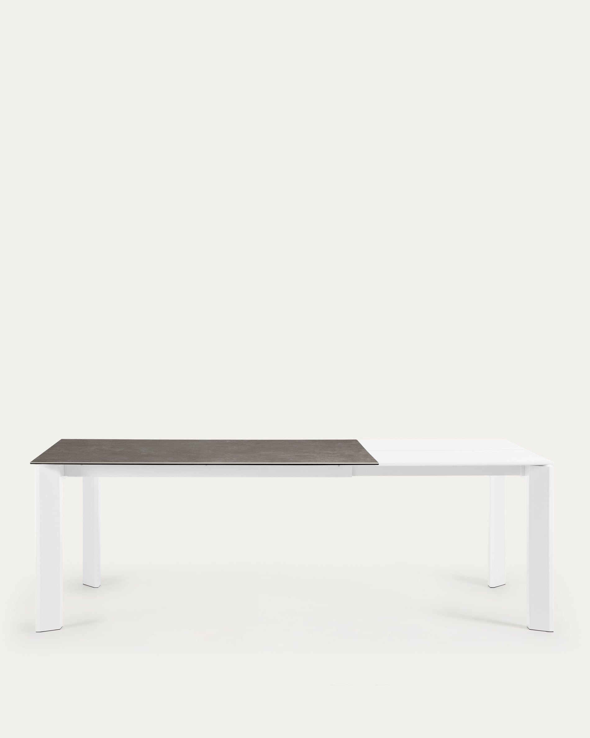 Eleganter Ausziehtisch mit Vulcano Ceniza Feinsteinzeugplatte und weißen Stahlbeinen, ausziehbar von 160 auf 220 cm.