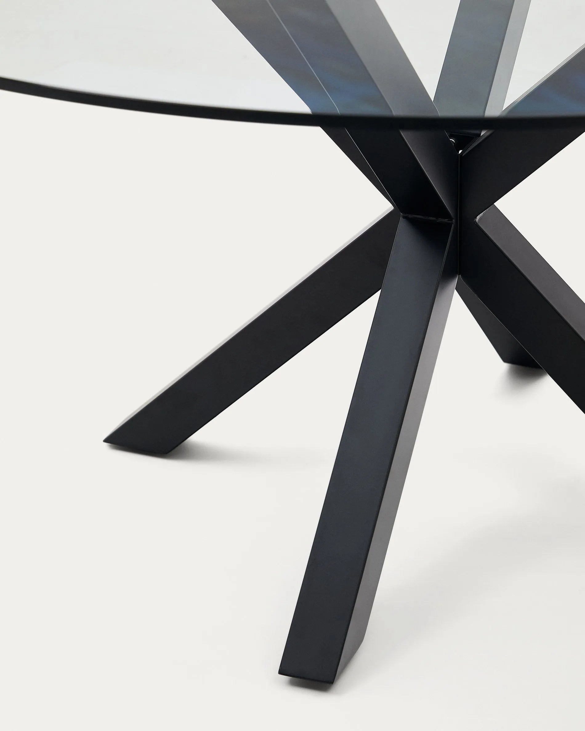 Eleganter Tisch Argo mit runder Glasplatte und schwarzen Stahlbeinen, Ø 150 cm, perfekt für moderne Wohn- und Esszimmer, von Kave Home.