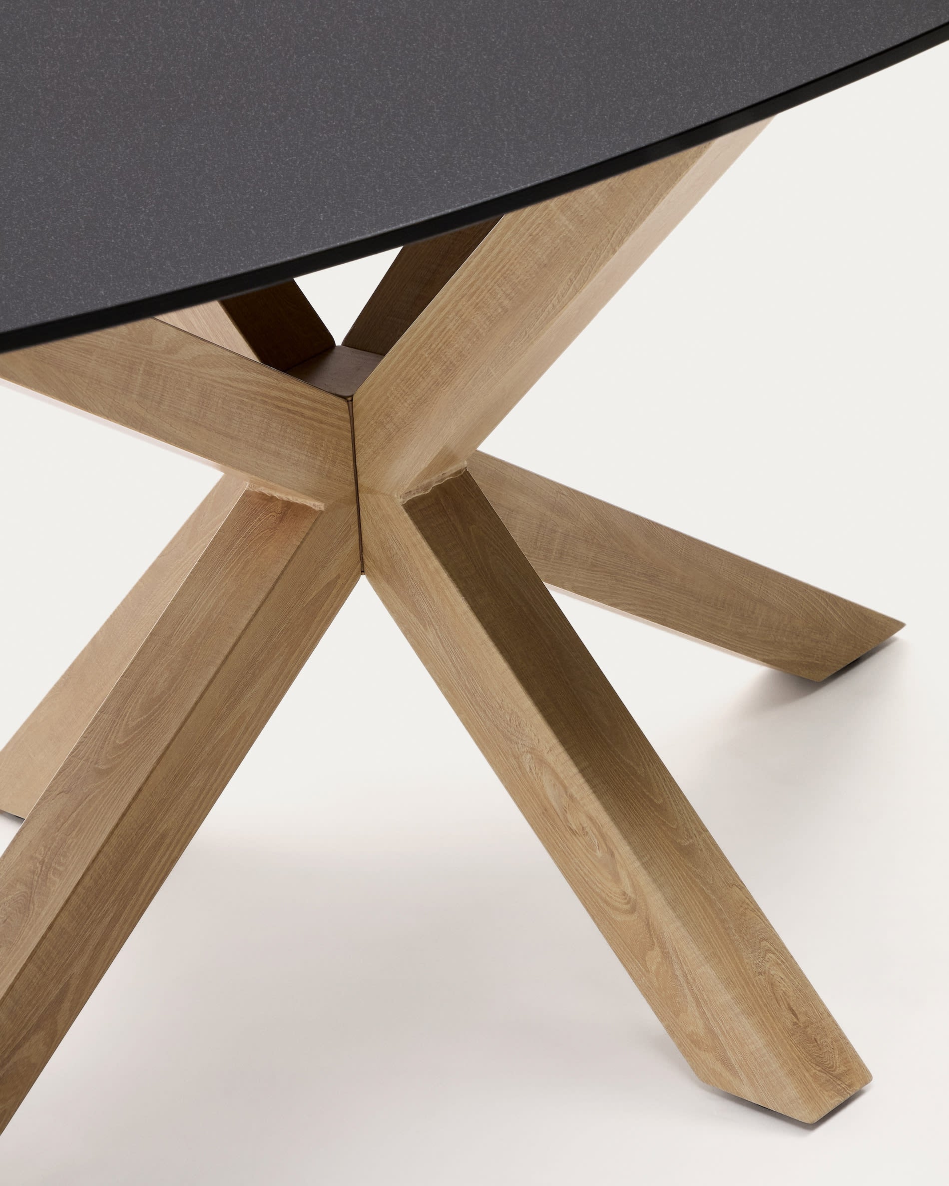 Eleganter ovaler Tisch Argo mit schwarzer Milchglasplatte und stilvollen Stahlbeinen in Holzoptik, ideal für moderne Esszimmer.