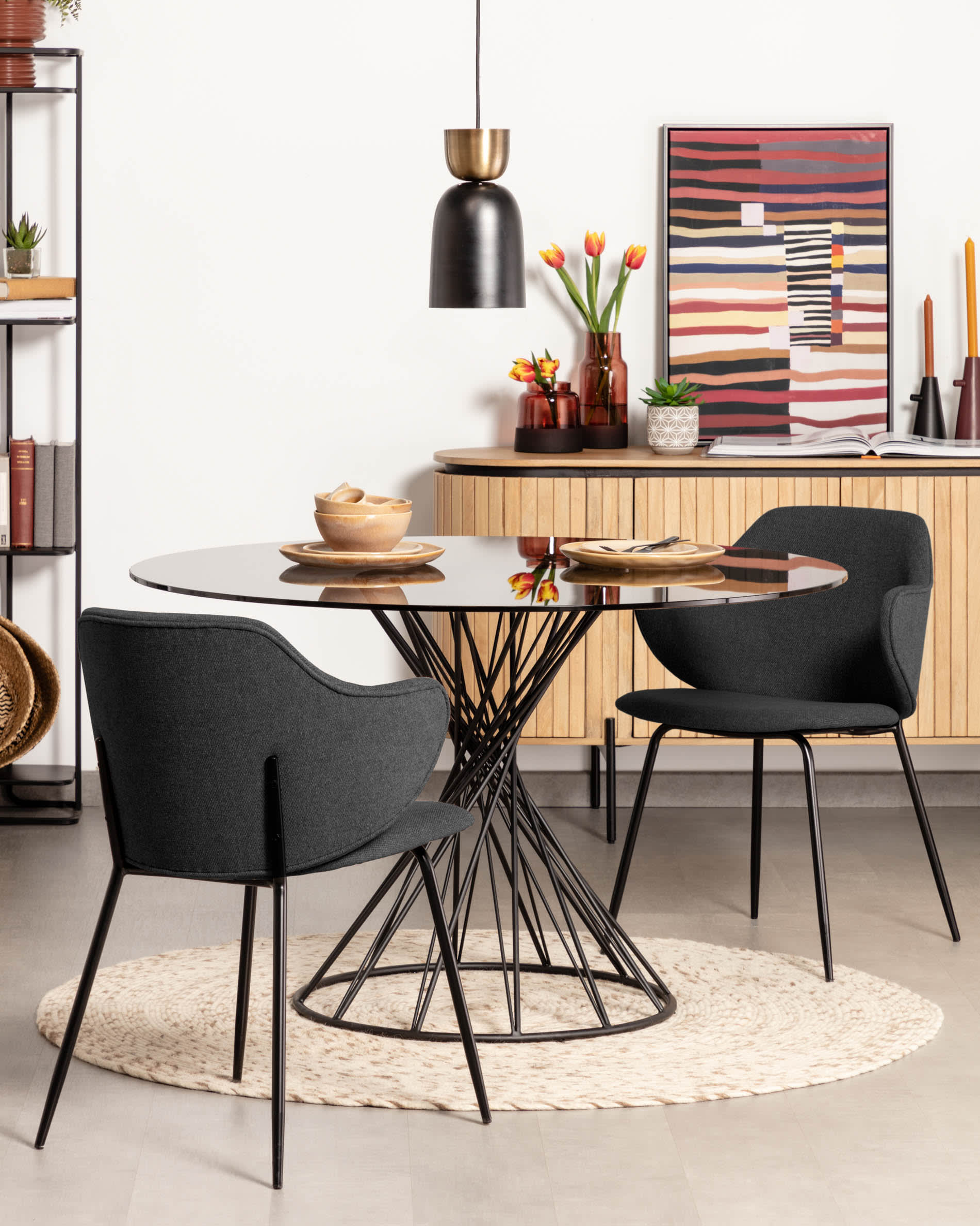 Eleganter runder Tisch mit Glasplatte und schwarzen Stahlbeinen, ideal für stilvolle Esszimmer.