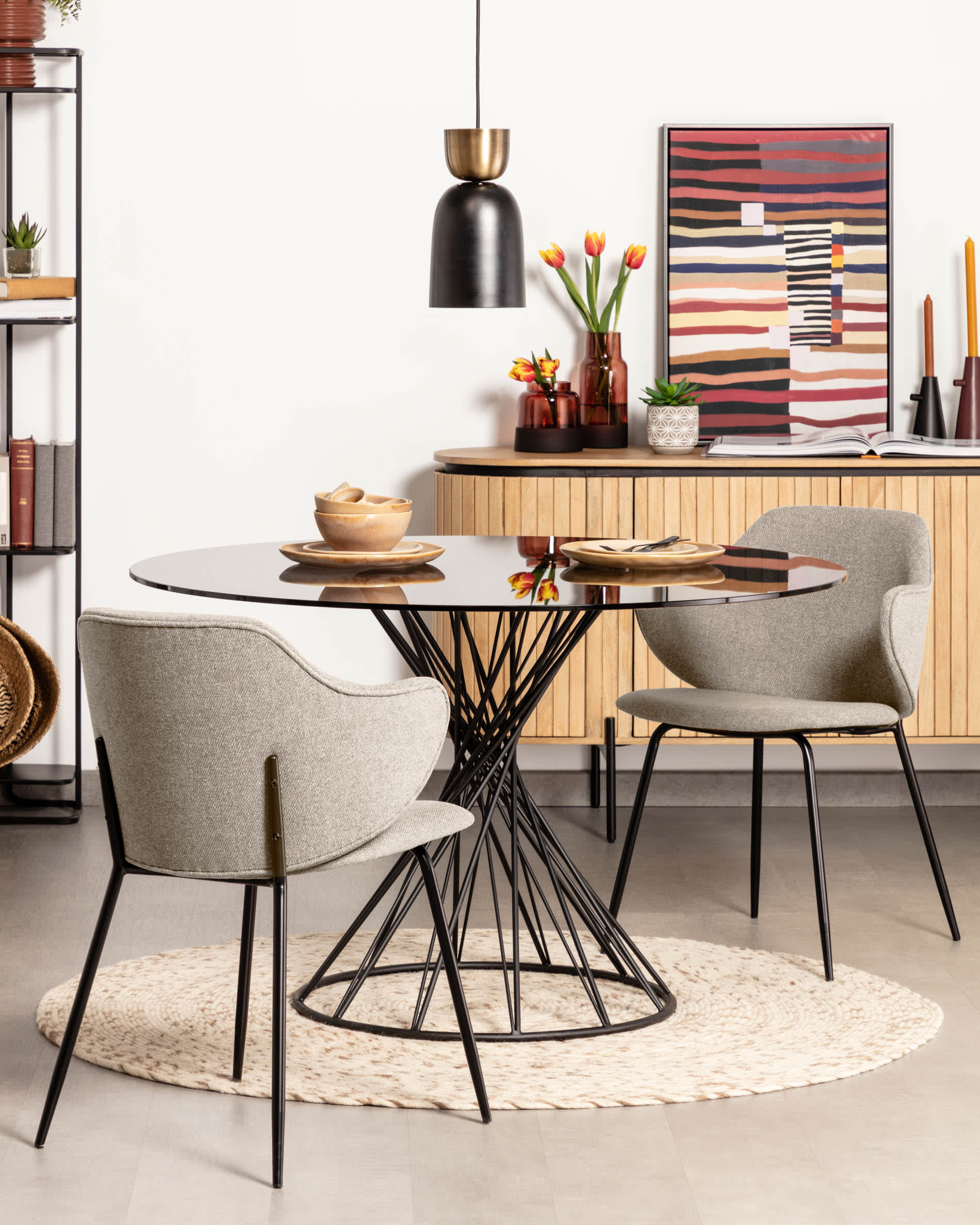 Eleganter runder Tisch mit Glasplatte und schwarzen Stahlbeinen, ideal für stilvolle Esszimmer.