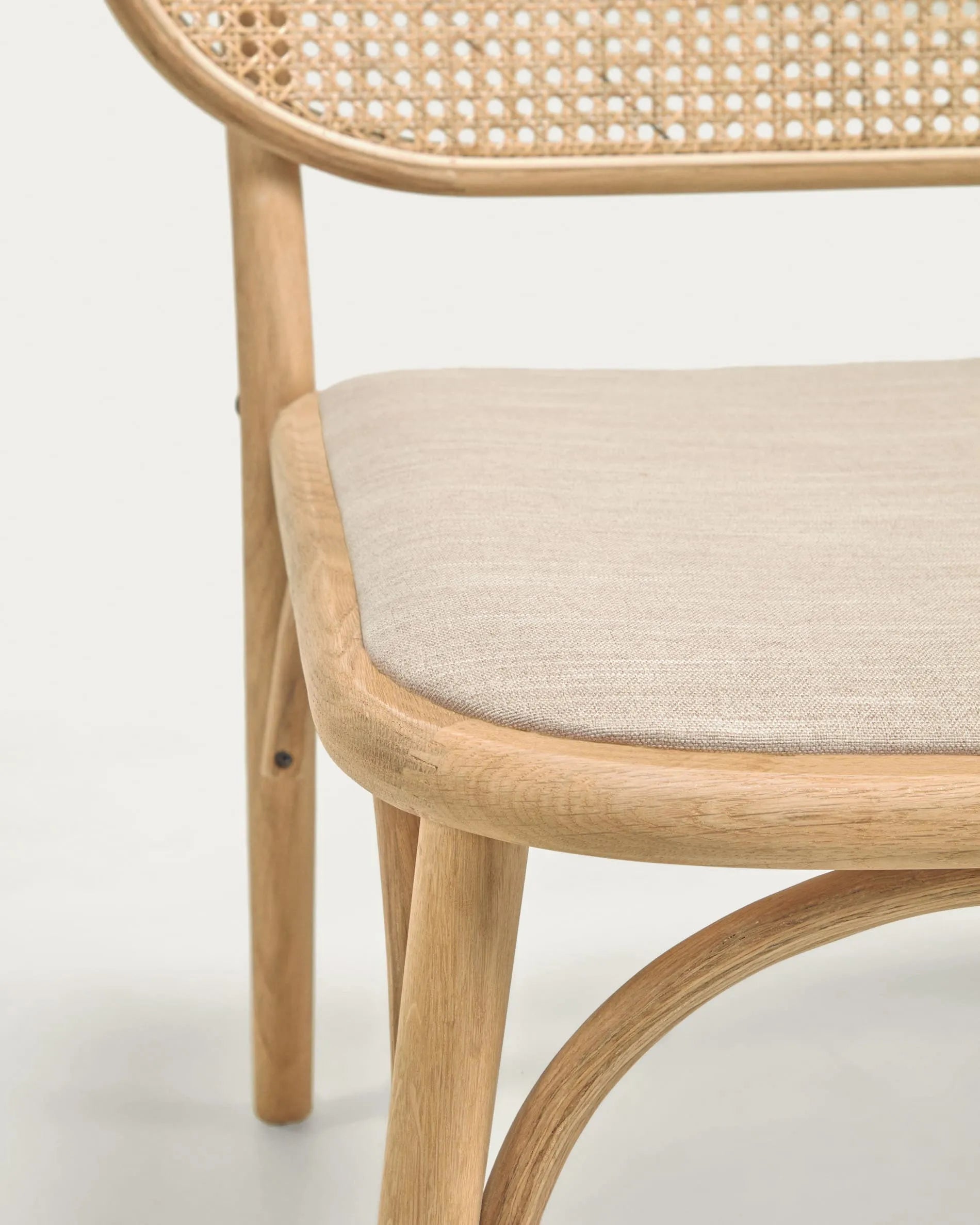 Eleganter Sessel aus massiver Eiche mit Naturfinish, gepolstertem Sitz und Rattanrücken, FSC-zertifiziert, stilvoll und nachhaltig.