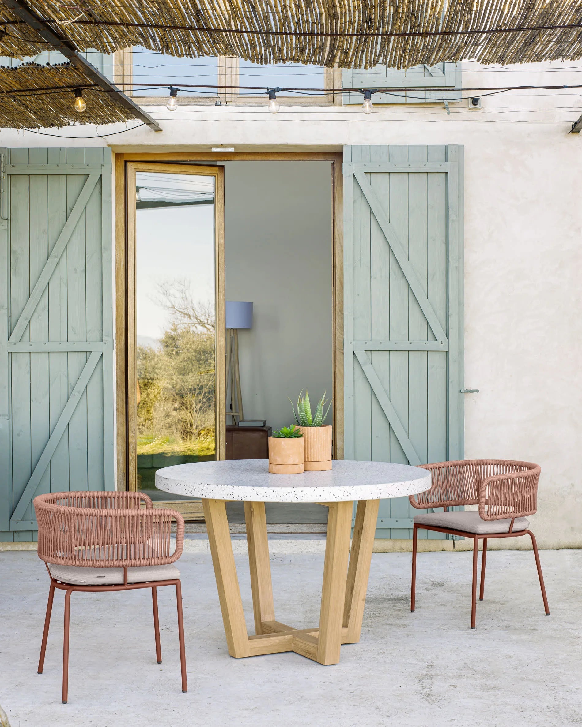 Eleganter runder Tisch mit weißer Terrazzo-Oberfläche und Akazienholzgestell, Ø 120 cm, perfekt für moderne Wohnräume, von Kave Home.