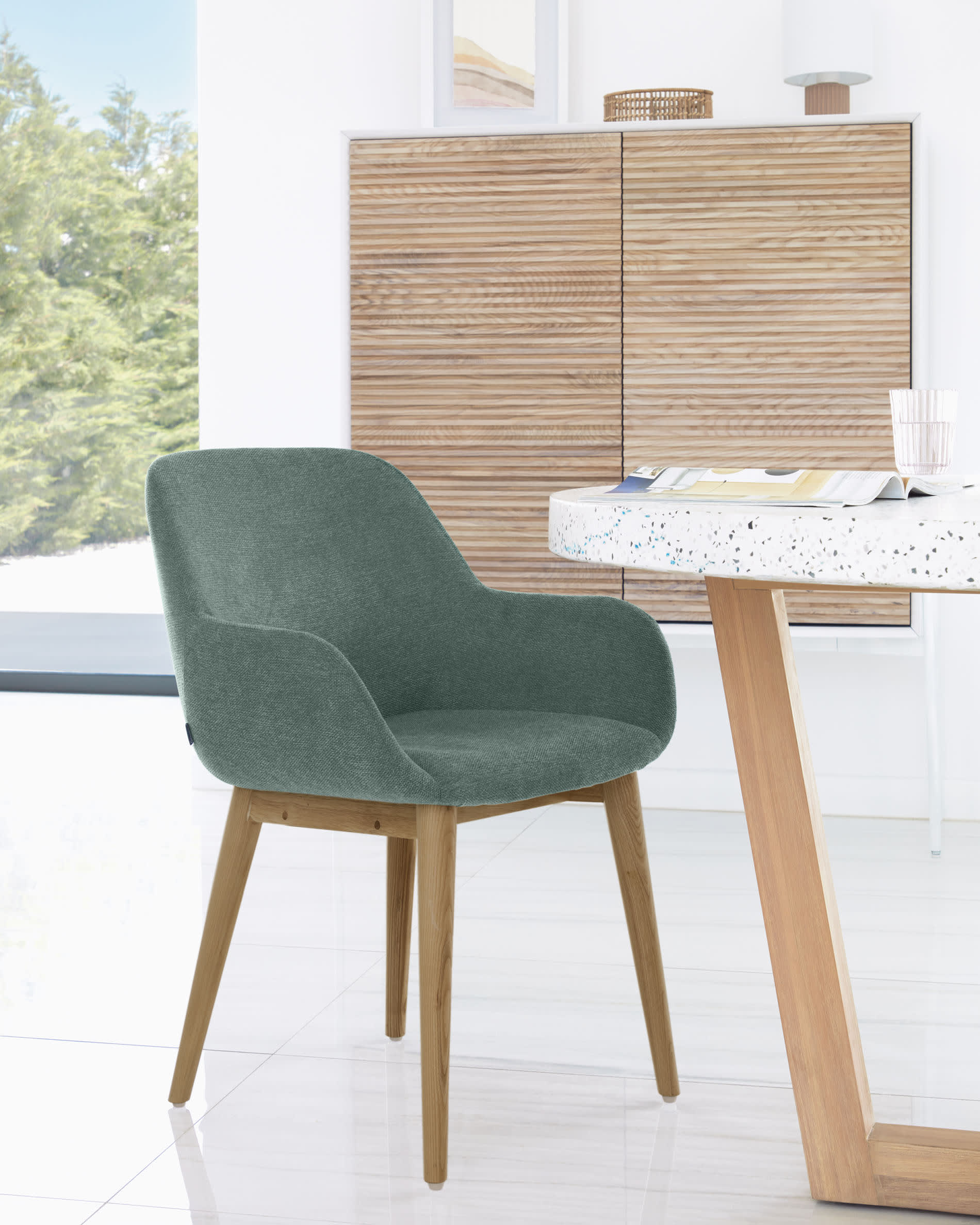Moderner runder Tisch mit weißer Terrazzo-Platte und Akazienholzgestell, Ø 120 cm, ideal für stilvolle Essbereiche, von Kave Home.