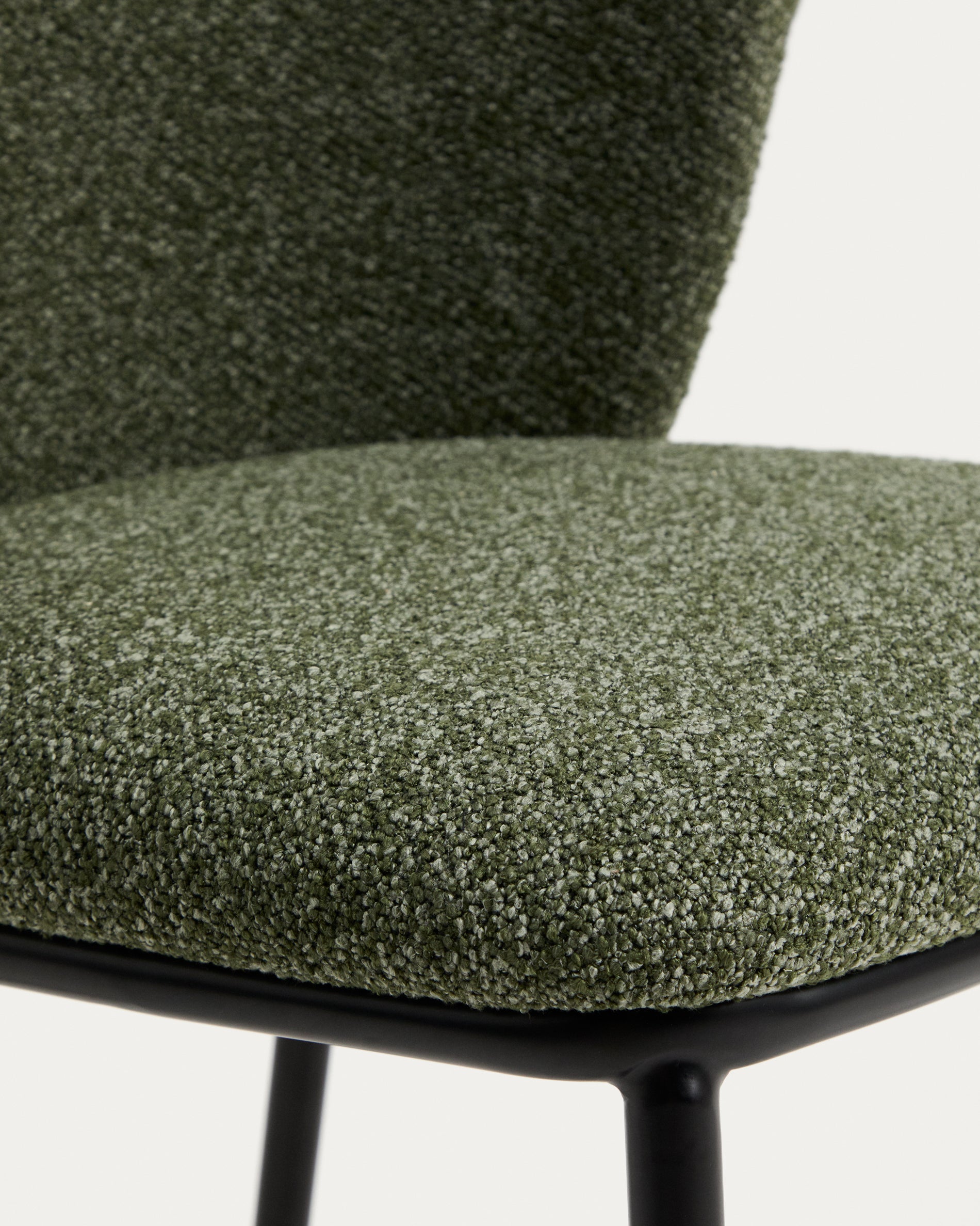 Eleganter Ciselia Stuhl in luxuriösem, dunkelgrünem Chenille, unterstützt von robusten Stahlbeinen mit schwarzem Finish – ideal für stilvolle Räume.