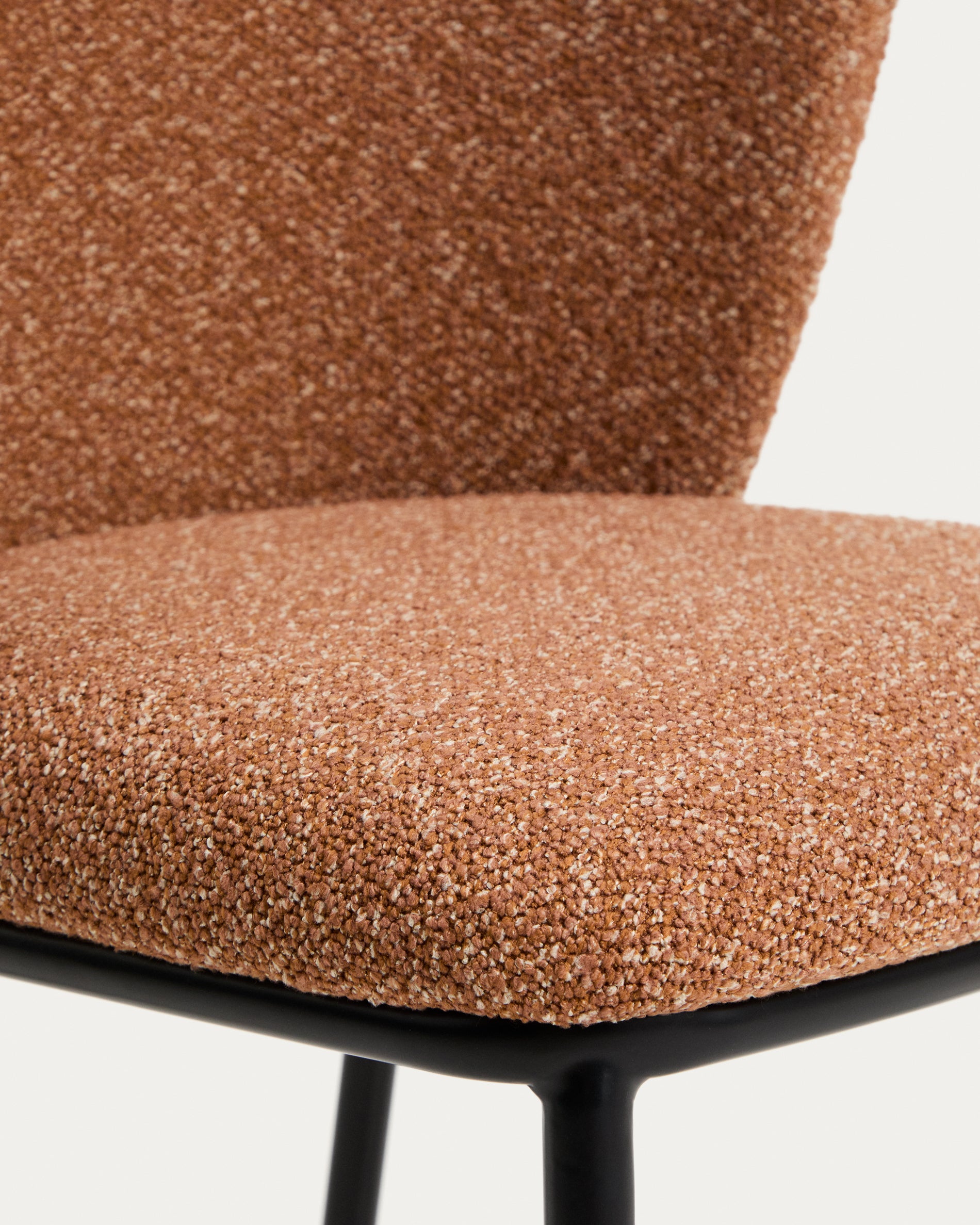 Eleganter Ciselia Stuhl in terrakottafarbener Chenille, kombiniert mit robusten Stahlbeinen in Schwarz – ideal für stilvolle Wohnräume.