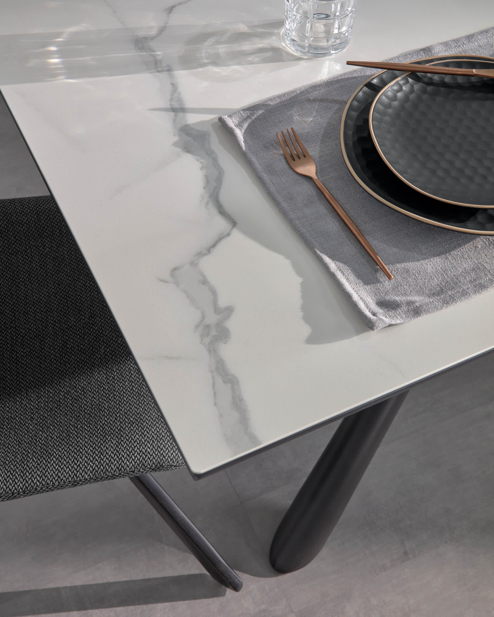 Eleganter Tisch mit weisser Feinsteinzeugplatte und schwarzen Stahlbeinen, ausziehbar von 160 auf 210 cm.