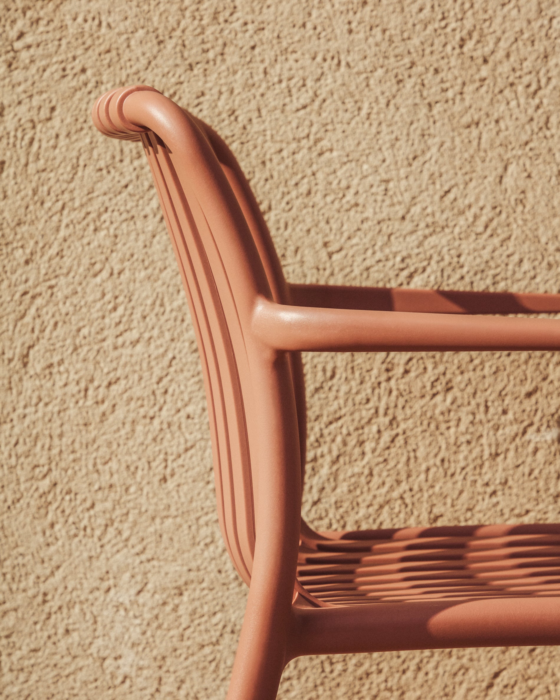 Stapelbarer Outdoor-Stuhl Isabellini in Terrakotta, perfekt für entspannte Momente im Garten oder auf der Terrasse, vereint Komfort und Stil.