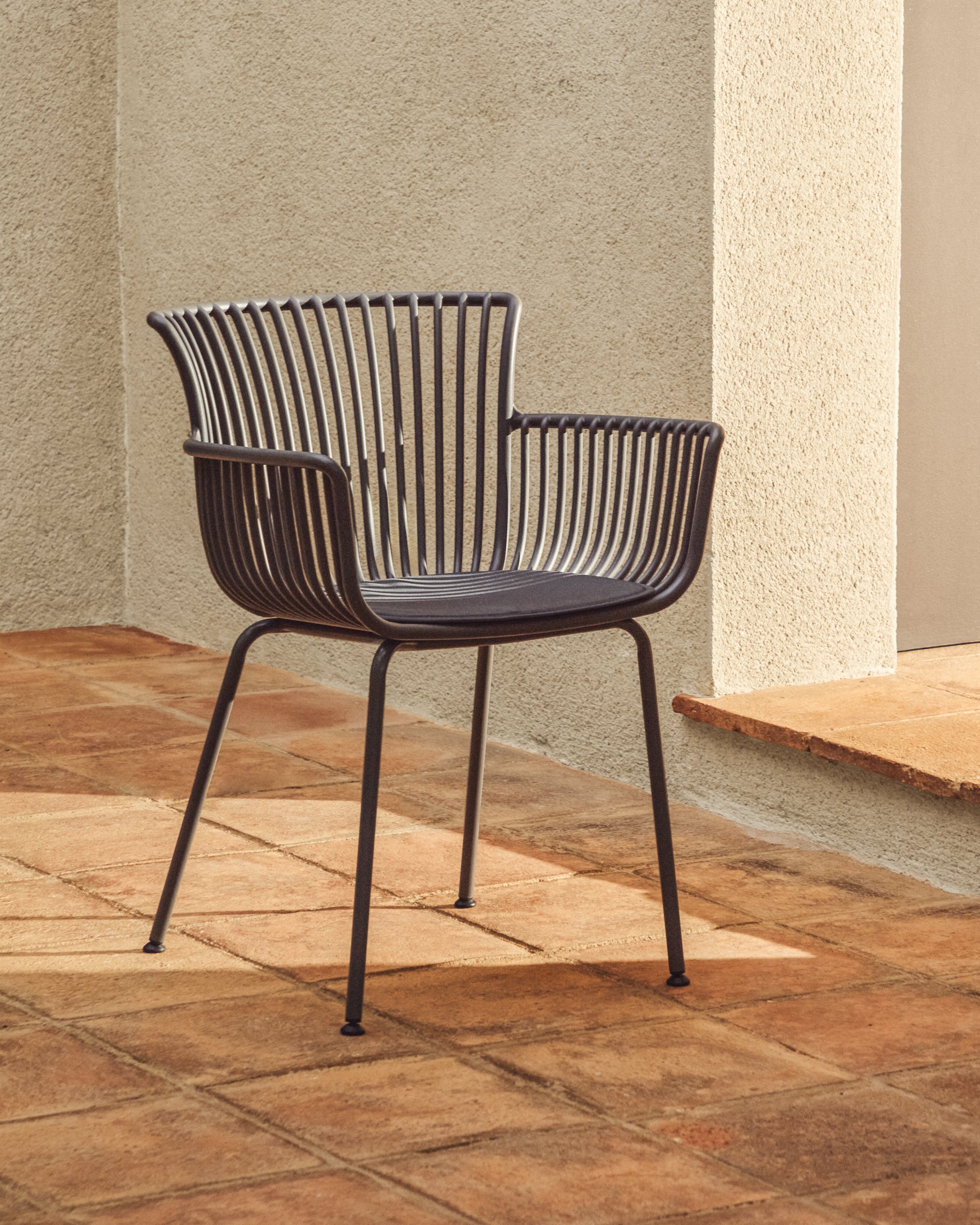 Eleganter Gartenstuhl Surpika mit stabilen graphitgrauen Stahlbeinen, perfekt für entspannte Stunden im Freien, von Kave Home.