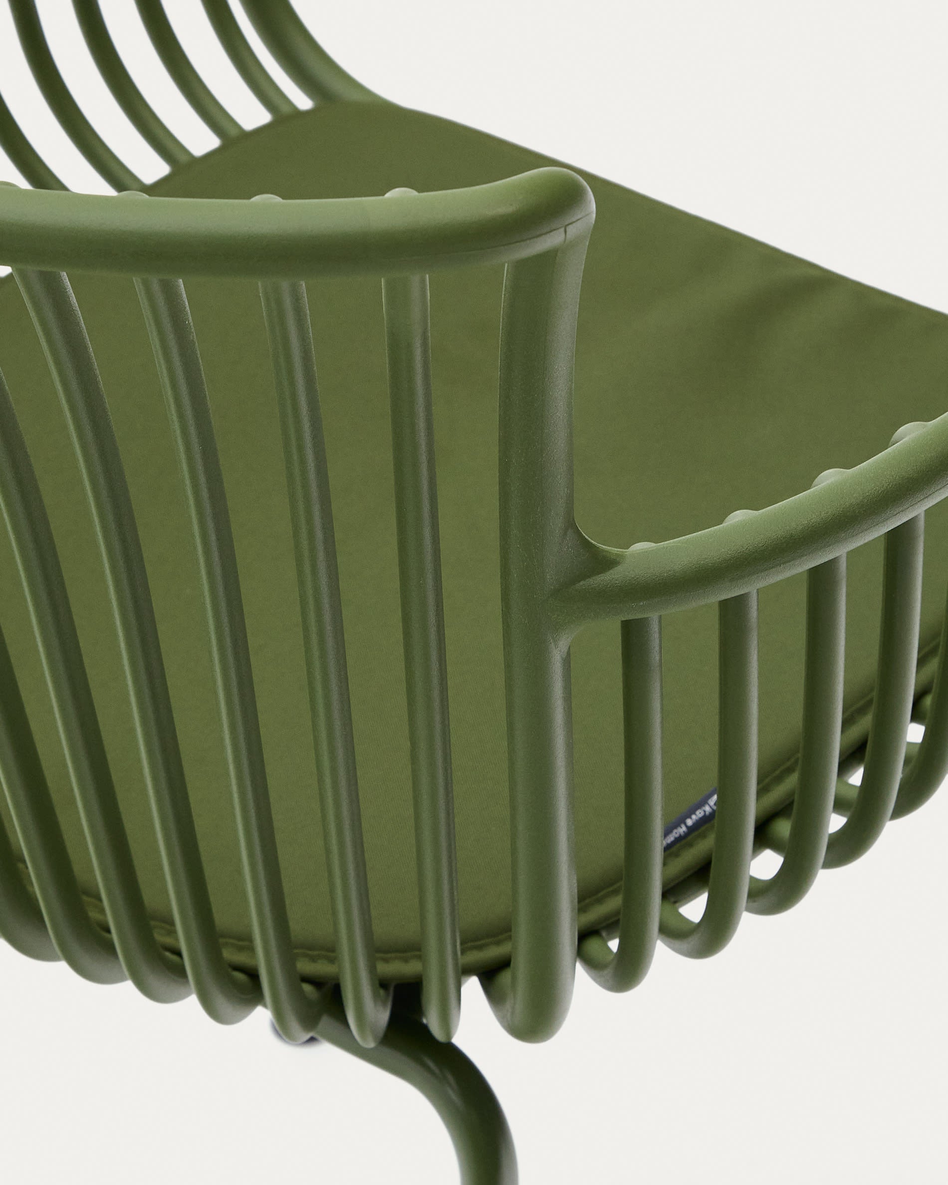 Der Surpika Outdoor-Stuhl von Kave Home besticht durch grüne Stahlbeine und modernes Design, ideal für stilvolle Außenbereiche.