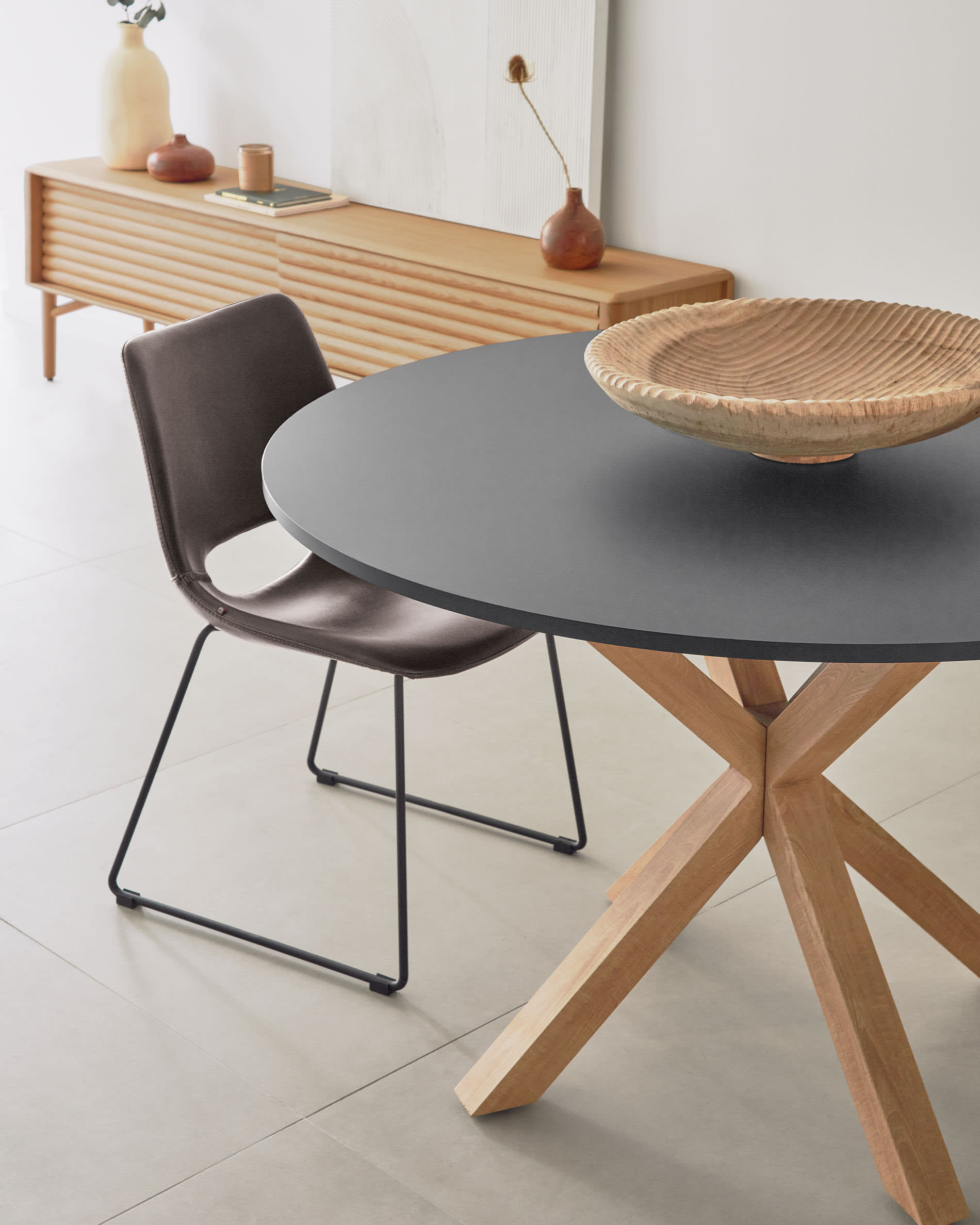 Eleganter runder Tisch Argo: Schwarz lackiertes MDF, Stahlbeine in Holzoptik, Ø 120 cm. Modernes Design für stilvolle Mahlzeiten.