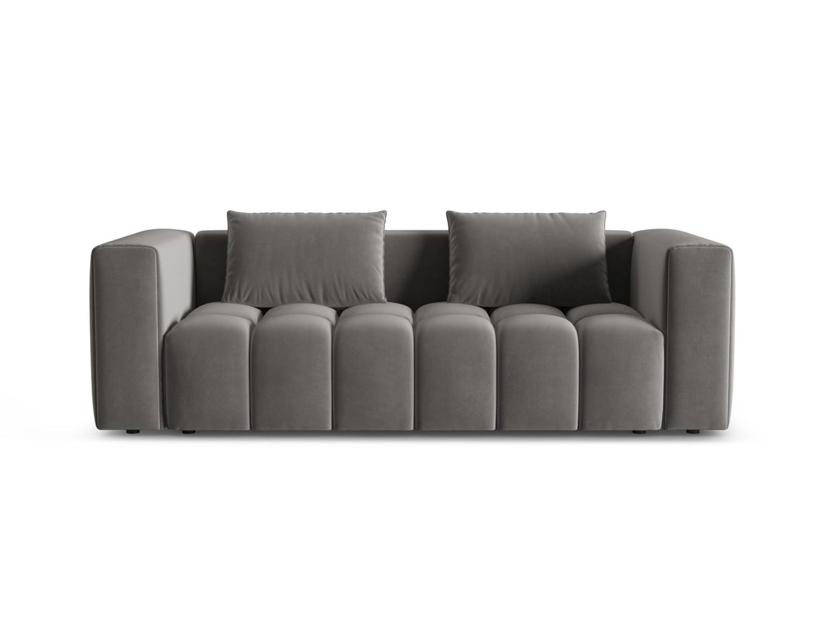 Sandfarbenes Samt-Bettsofa Verona mit drei Sitzplätzen, ausklappbarer Liegefläche, Bettkasten und schwarzen Kunststoffbeinen im Wohnraum.
