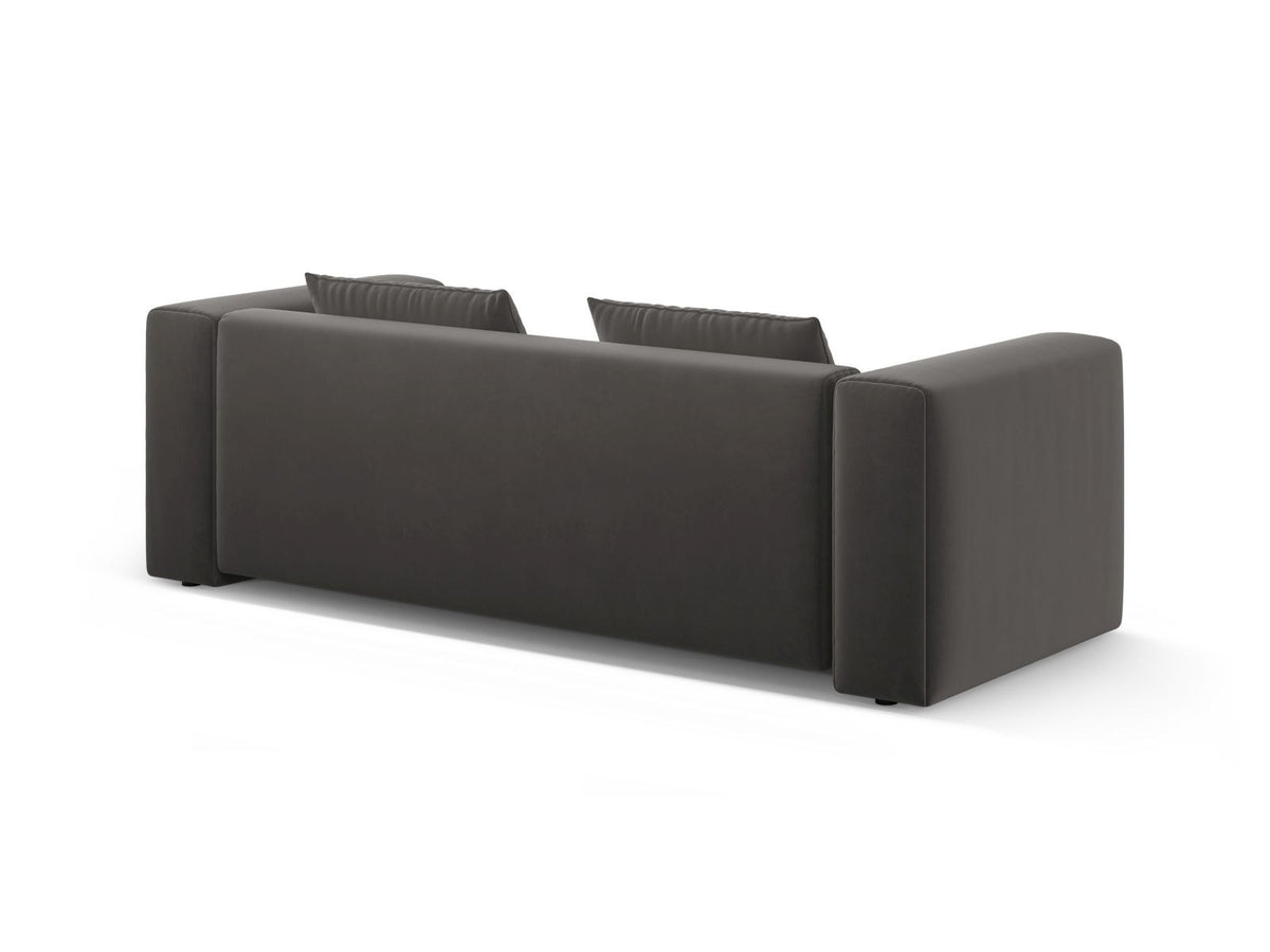 Sandfarbenes Samt-Bettsofa Verona mit drei Sitzplätzen, ausklappbarer Liegefläche, Bettkasten und schwarzen Kunststoffbeinen im Wohnraum.