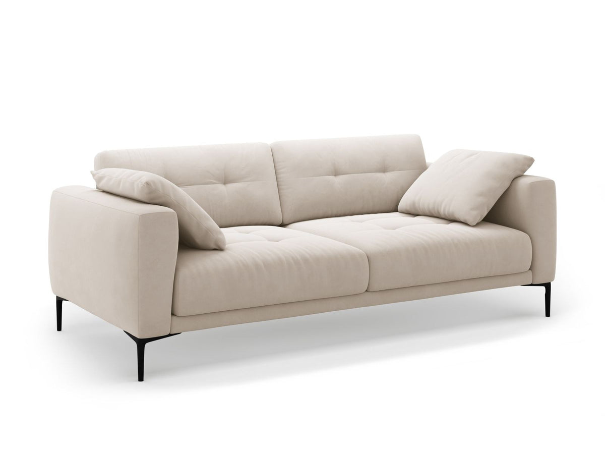 Beige Samt-Sofa Lazio mit 4 Sitzplätzen, Massivholzrahmen, Sitzpolster und schwarzen Metallbeinen, Frontalansicht im Wohnraum.