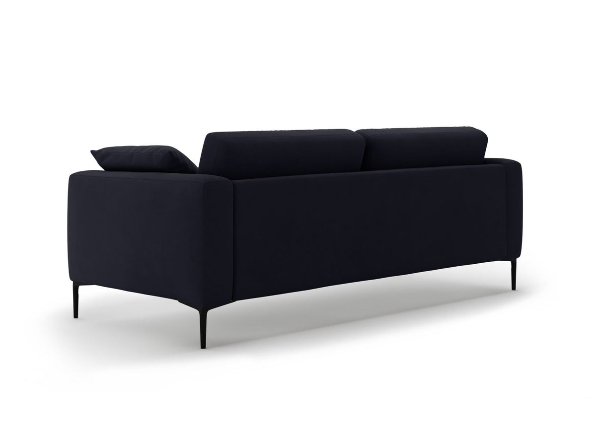 Beige Samt-Sofa Lazio mit 4 Sitzplätzen, Massivholzrahmen, Sitzpolster und schwarzen Metallbeinen, Frontalansicht im Wohnraum.