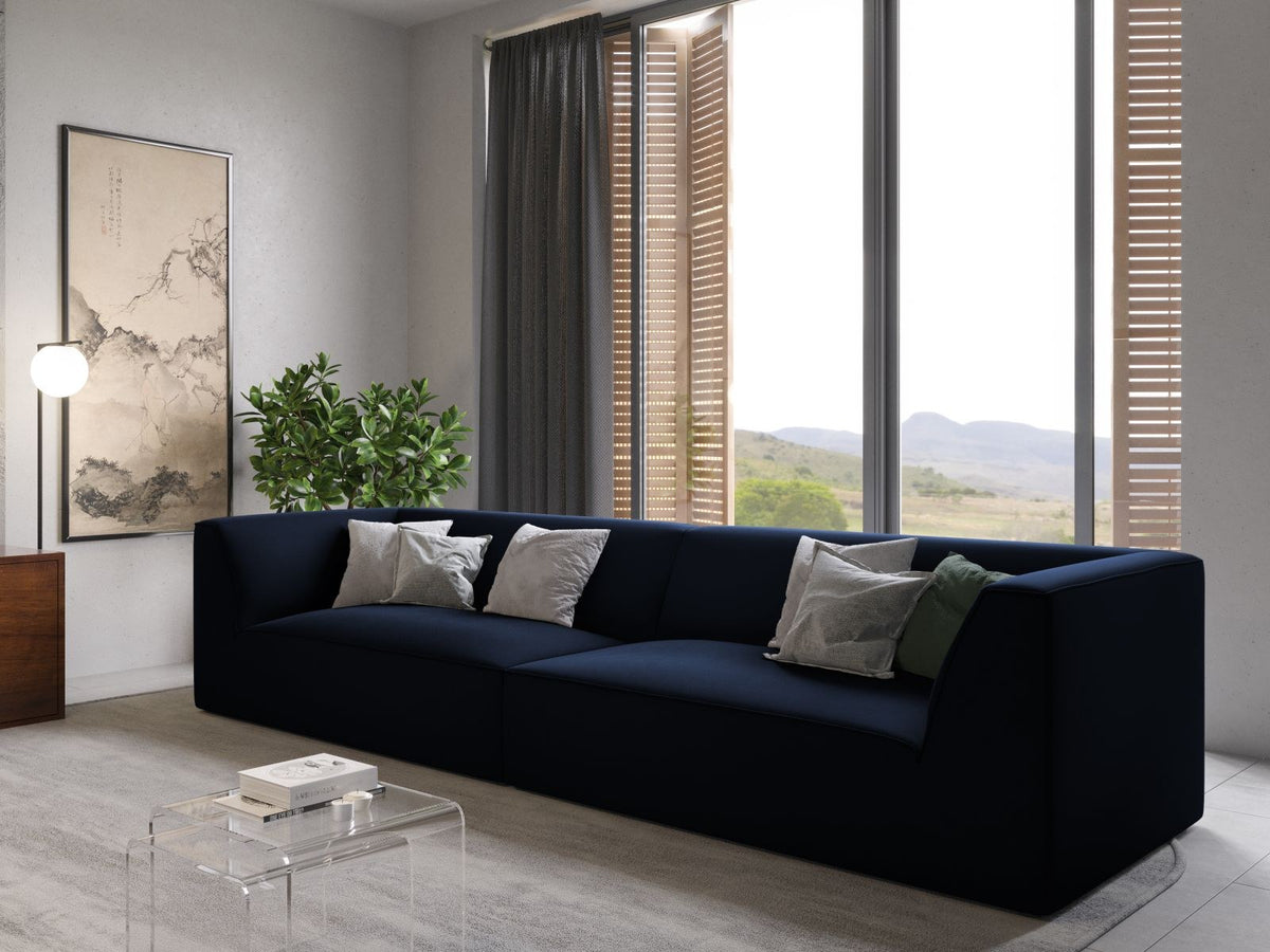 Beige-farbenes 4er Sofa Siena mit Samtbezug, schwarzen Kunststoffbeinen und gepolsterter Rückenlehne, Frontalansicht auf hellem Hintergrund.