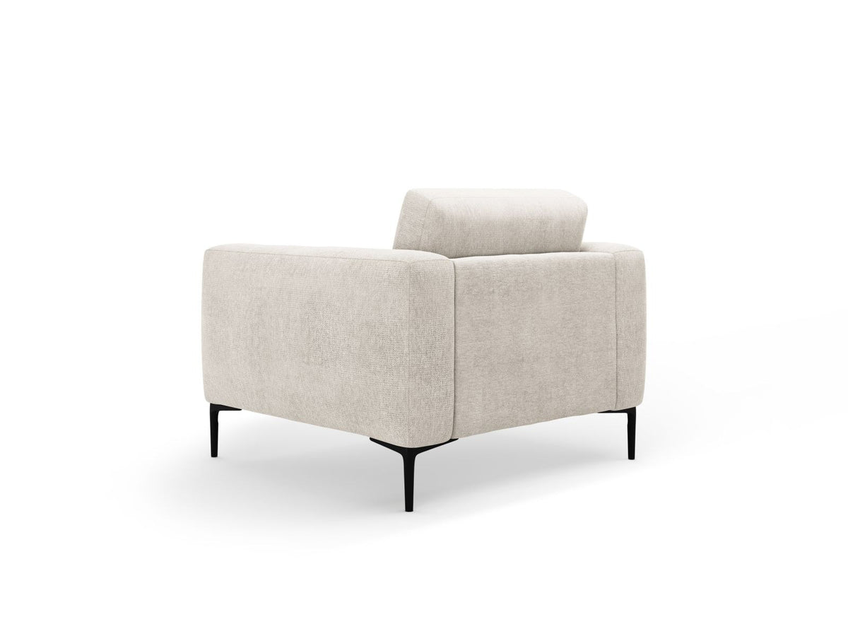 Beige gepolsterter Sessel mit Sorella-Stoffbezug, schwarzen Metallbeinen und Massivholzrahmen, Frontalansicht auf weissem Hintergrund.