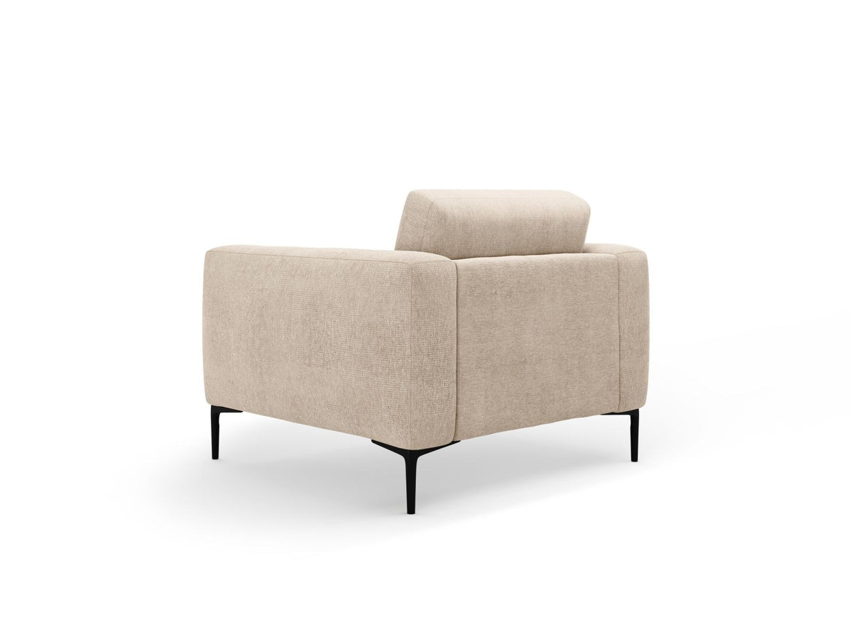 Beige gepolsterter Sessel mit Sorella-Stoffbezug, schwarzen Metallbeinen und Massivholzrahmen, Frontalansicht auf weissem Hintergrund.