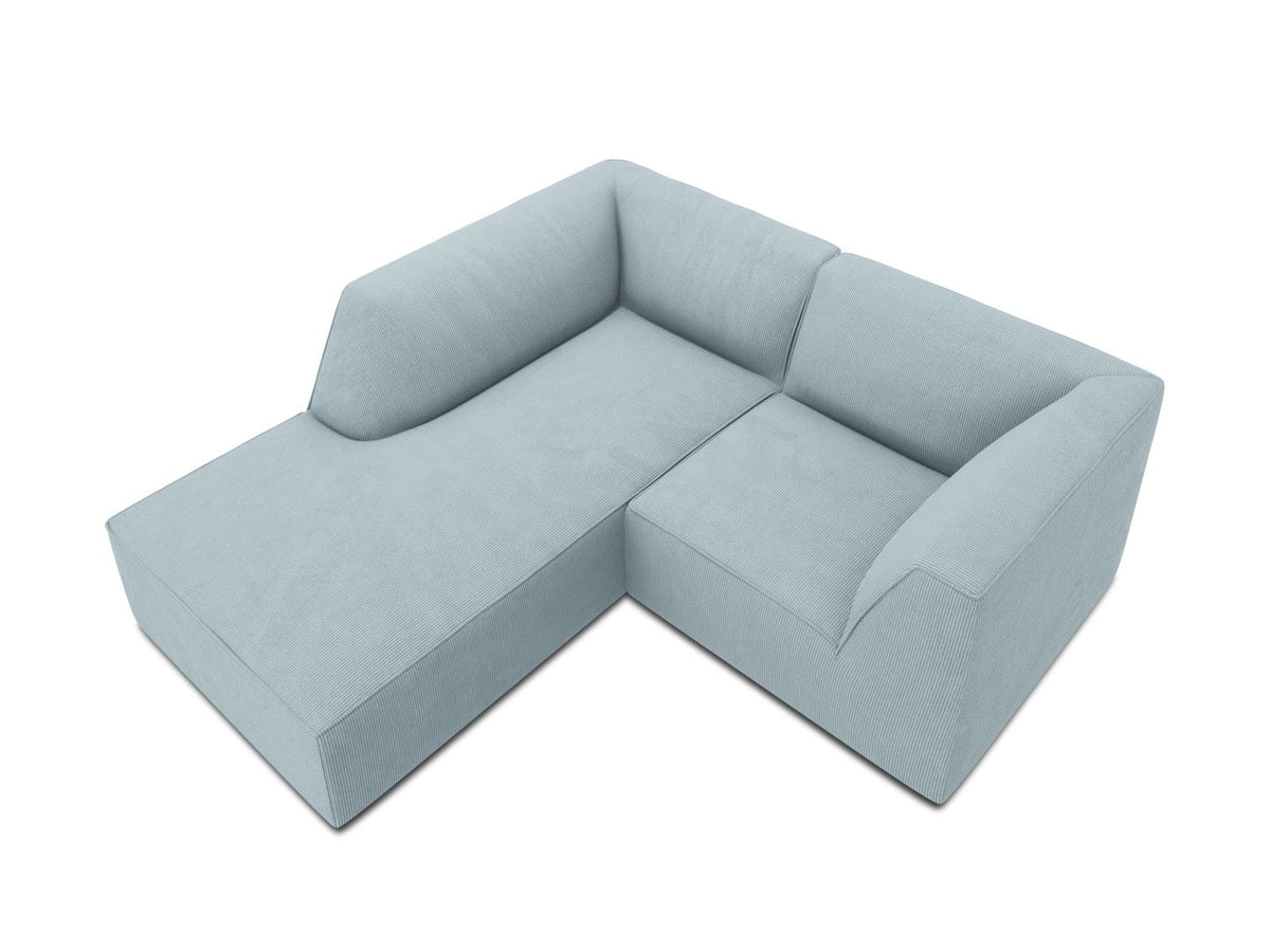 Modulares Ecksofa Siena mit gelbem Ottawa-Stoffbezug, schwarzen Kunststoffbeinen und Récamiere, Ansicht von vorne im Wohnraum.