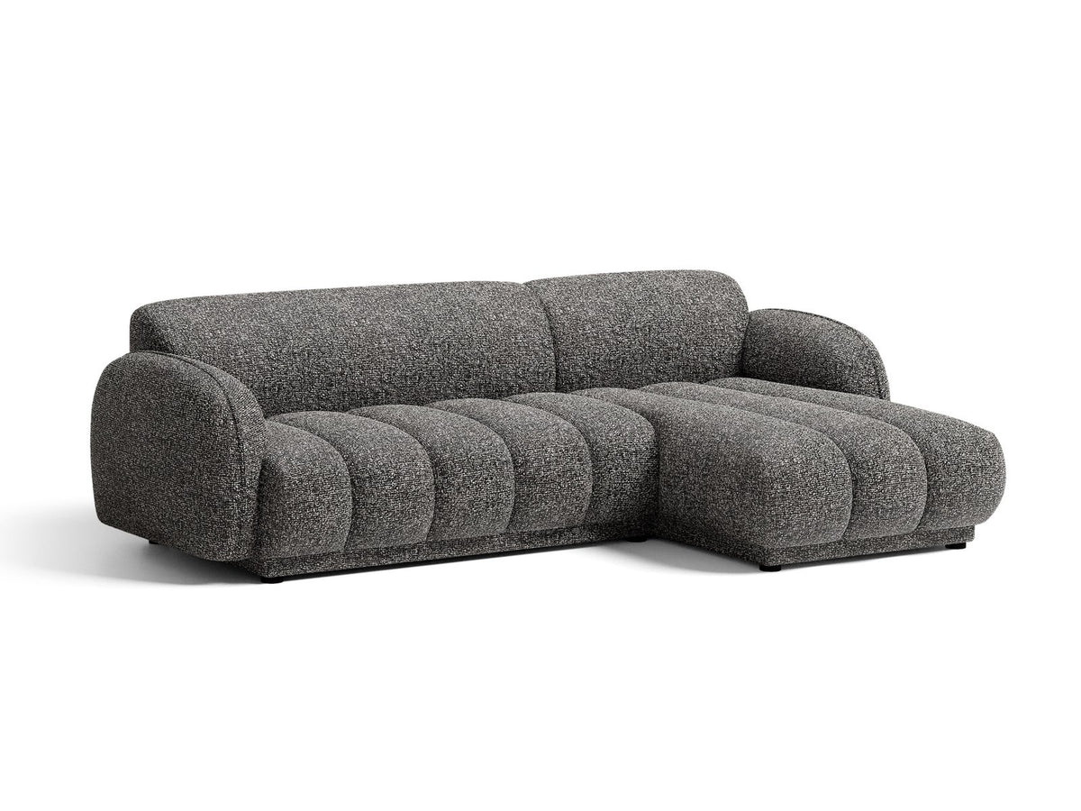 Beiges Ecksofa Bilbao mit Bouclé-Stoff Miles Sand, rechtsseitiger Récamiere, schwarzen Kunststoffbeinen und klarer, moderner Formgebung.