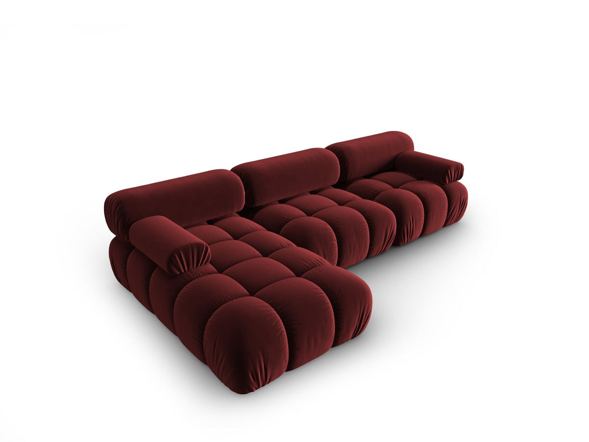 Modulares Ecksofa mit rosa Samtstoff, schwarzen Kunststoffbeinen und gepolsterter Récamiere, Ansicht von vorne links.