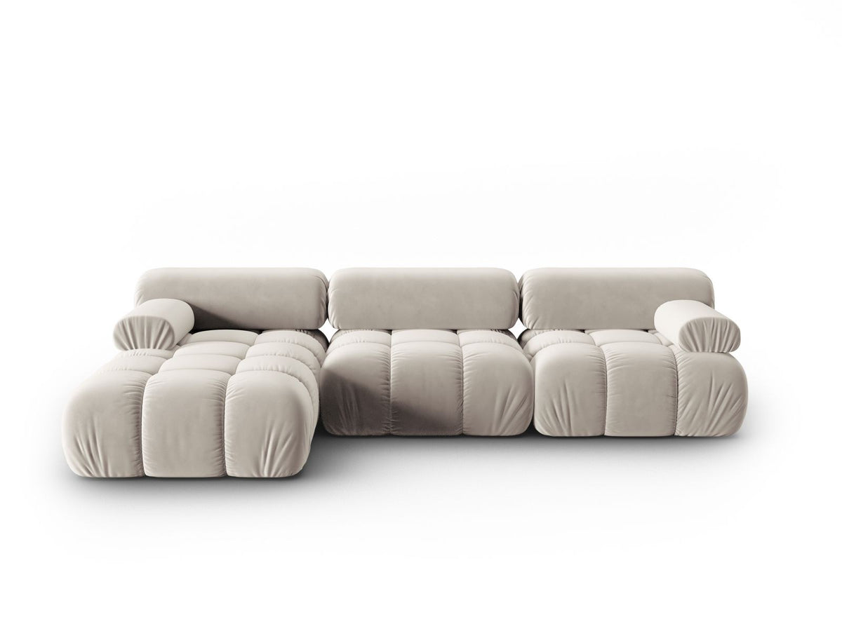 Modulares Ecksofa mit rosa Samtstoff, schwarzen Kunststoffbeinen und gepolsterter Récamiere, Ansicht von vorne links.