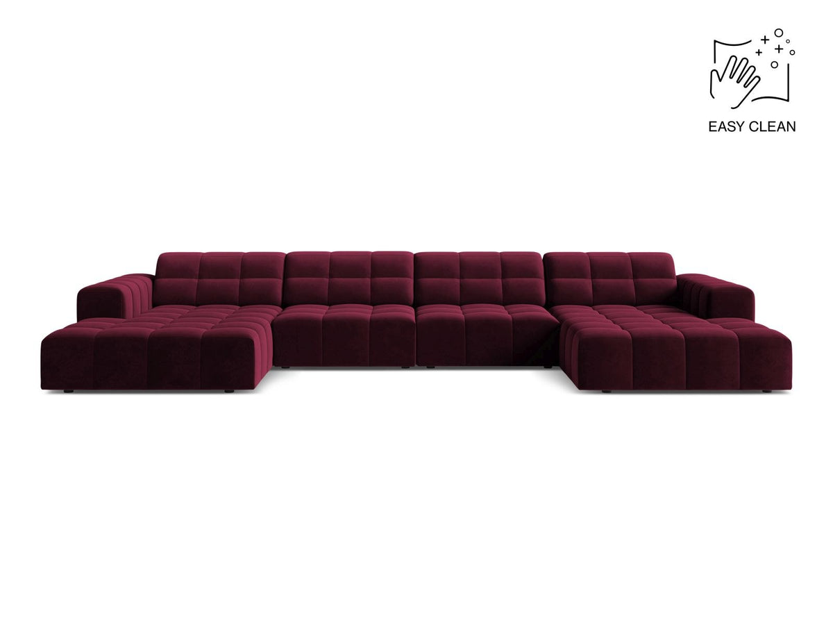 Beige-farbenes Panoramic-Sofa mit Samtbezug, sechs Sitzplätzen, abgewinkelter Rückenlehne und schwarzen Kunststoffbeinen.