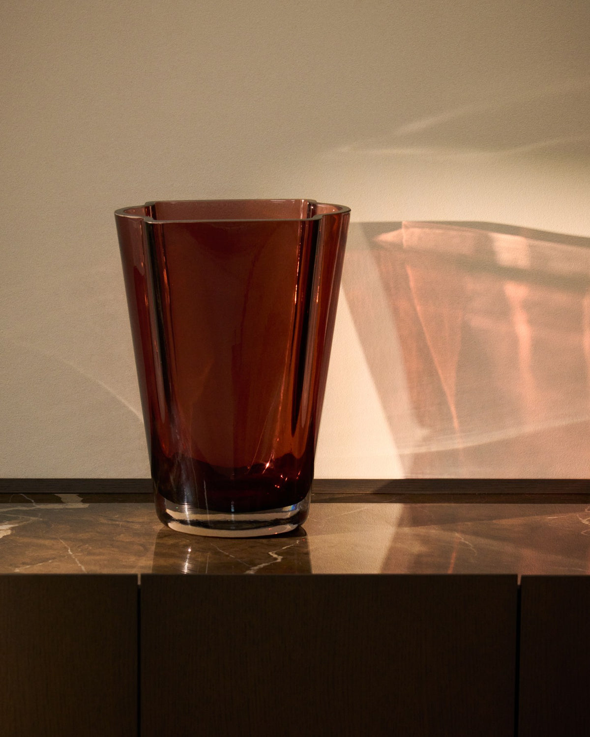 Burgunderrote Glasvase Uconi von Kave Home, 35 cm hoch, mit facettierter Oberfläche und dickem, mundgeblasenem Glas.