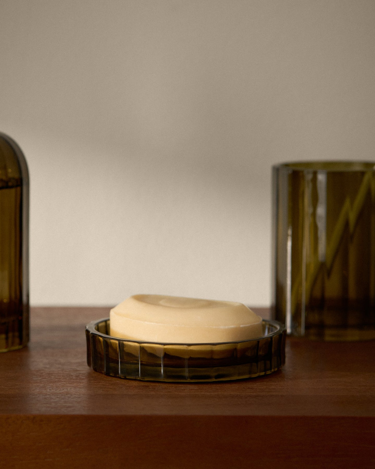 Seifenschale aus grünem Glas mit farbiger Oberfläche, schlichte runde Form, stehend auf ebener Fläche im Badezimmer, Badzubehör von Kave Home.