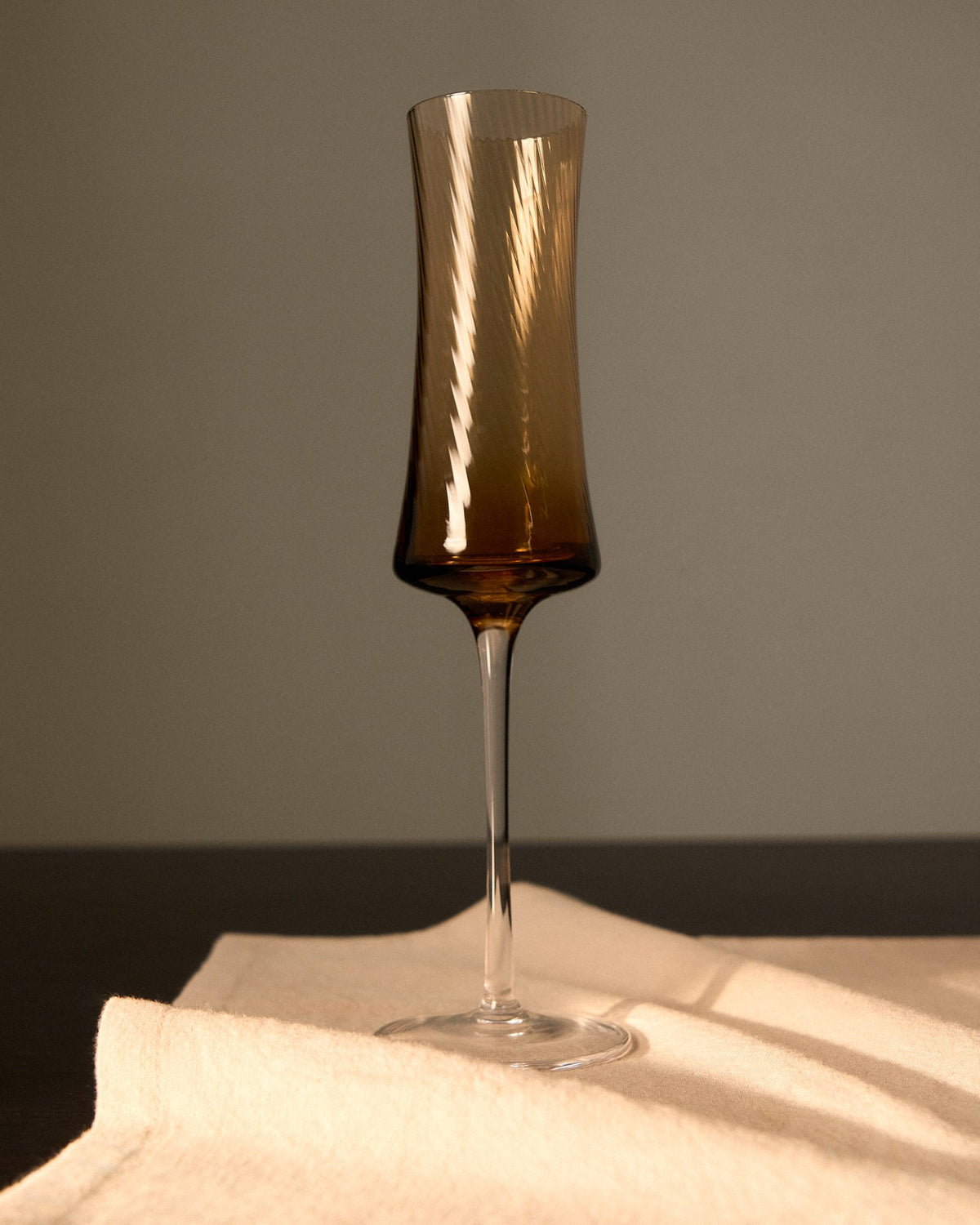 Hellorangefarbenes Sektglas aus Bernsteinglas mit dezentem Relief, schlanke Form, Fassungsvermögen 15 cl, Material 100% Glas.