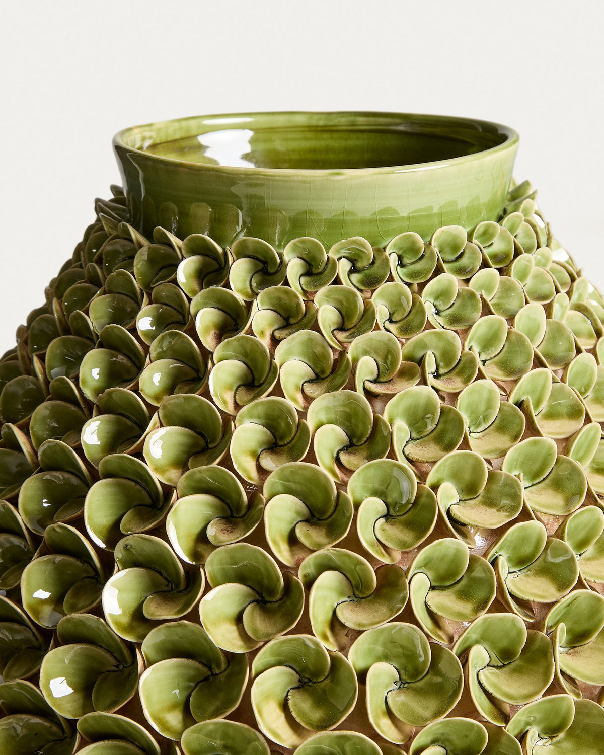 Hellgrüne Keramikvase Ederia von Kave Home mit floralen, handgeformten Blütenelementen, glasierter Oberfläche und rundlicher Form.