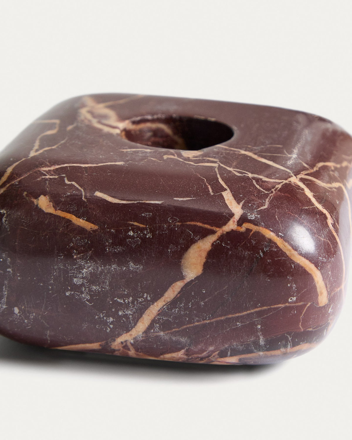 Kleiner runder Kerzenständer aus weinrotem Marmor mit naturbelassener Oberfläche und individueller Maserung, Höhe 4 cm.